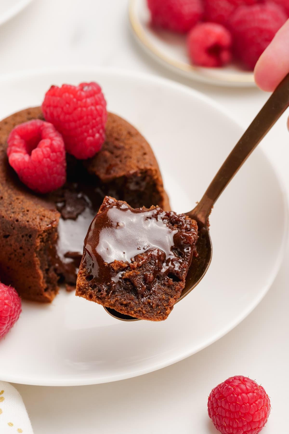 molten-lava-cake with raspberries on plates with spooned out filling