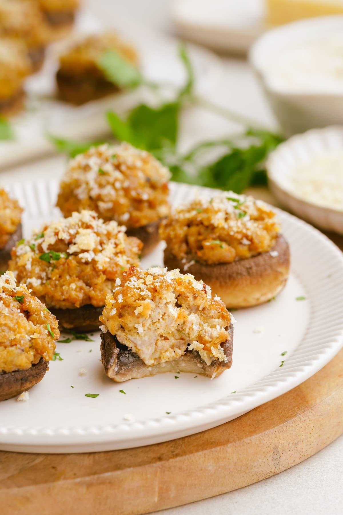 sausage stuffed mushrooms 22 bite taken out of sausage-stuffed-mushrooms on plate