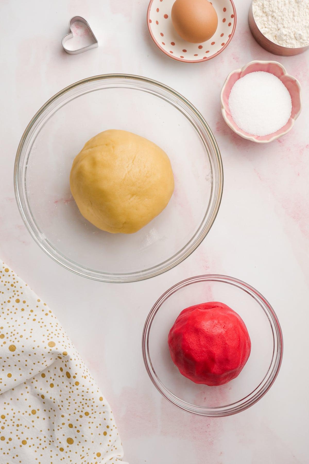 sugar cookie dough divided in bowls. 