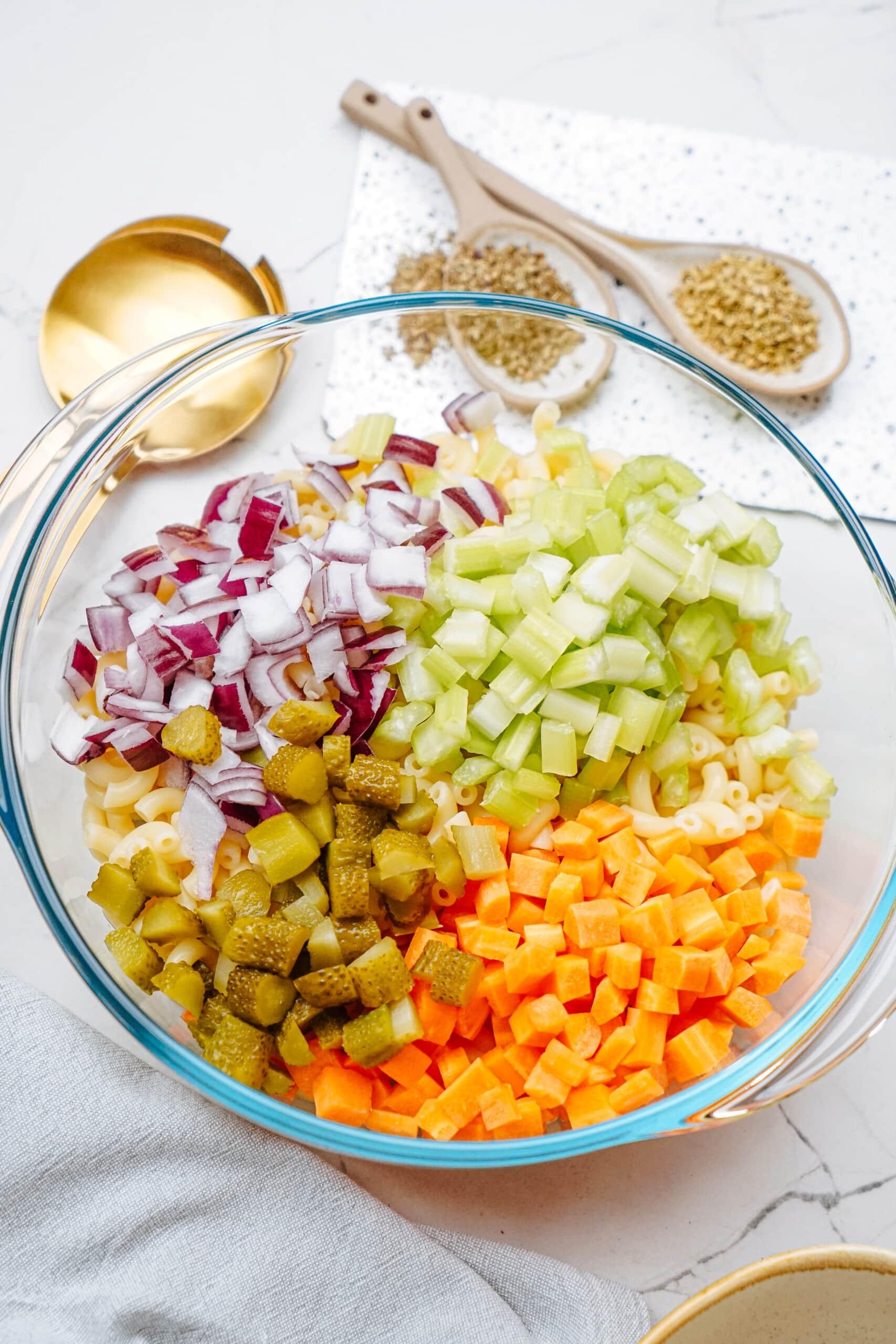 chopped veggies added to macaroni bowl