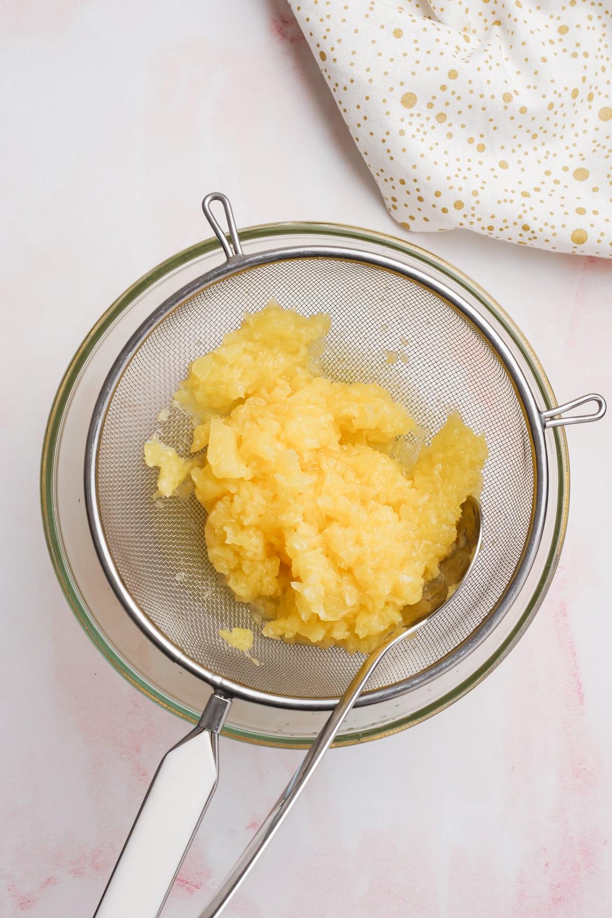 crushed pineapple in strainer to drain