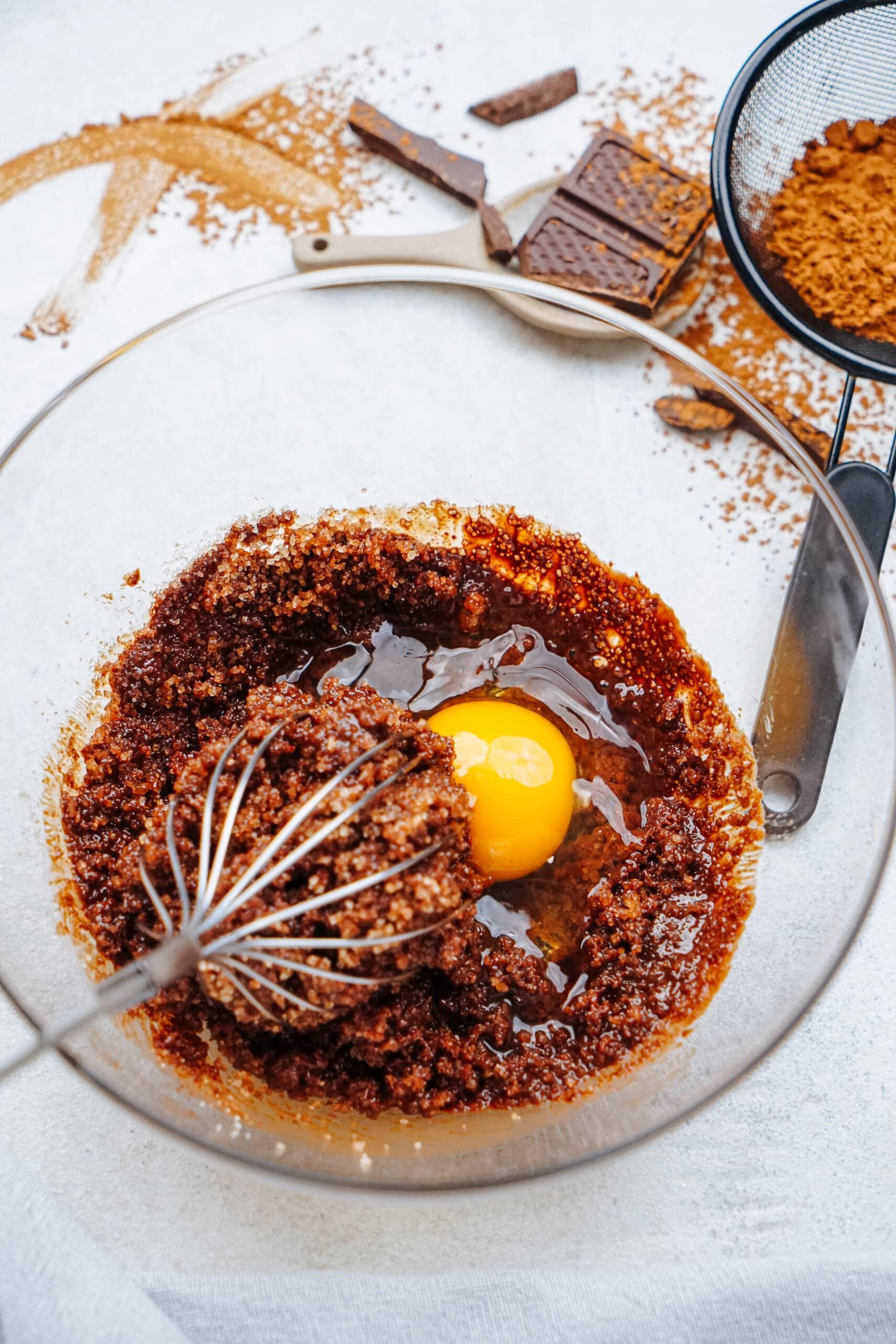 brownie batter ingredients with an egg and whisk