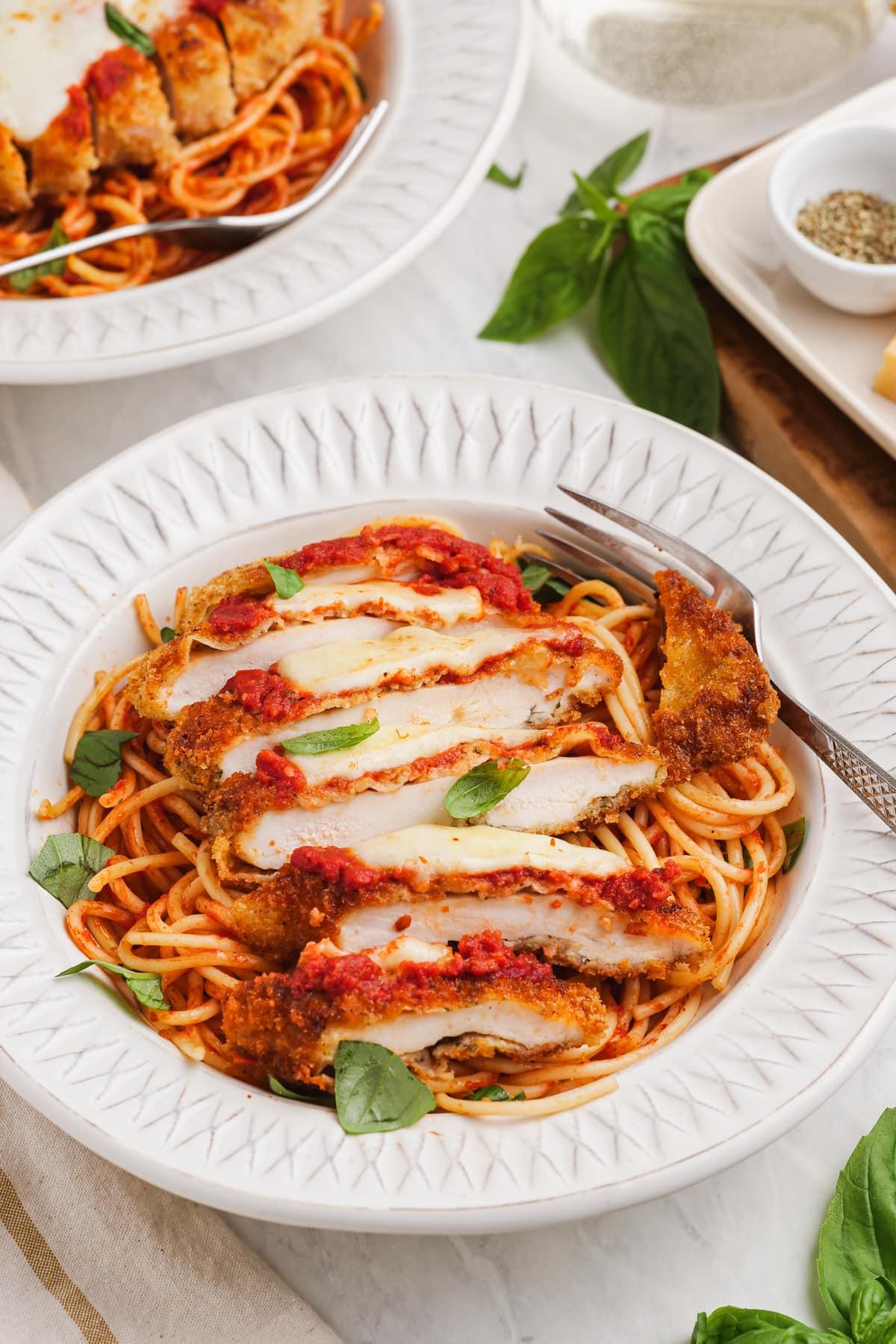 chicken parmesan-sliced breaded chicken over pasta and marinara