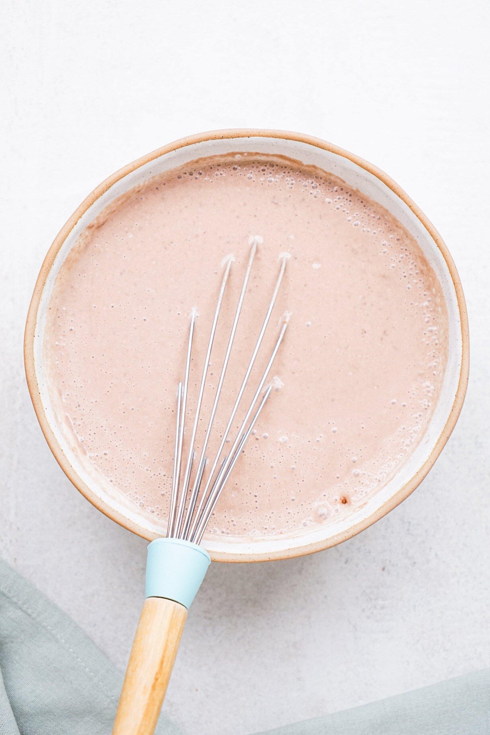 chocolate pudding in a bowl with whisk