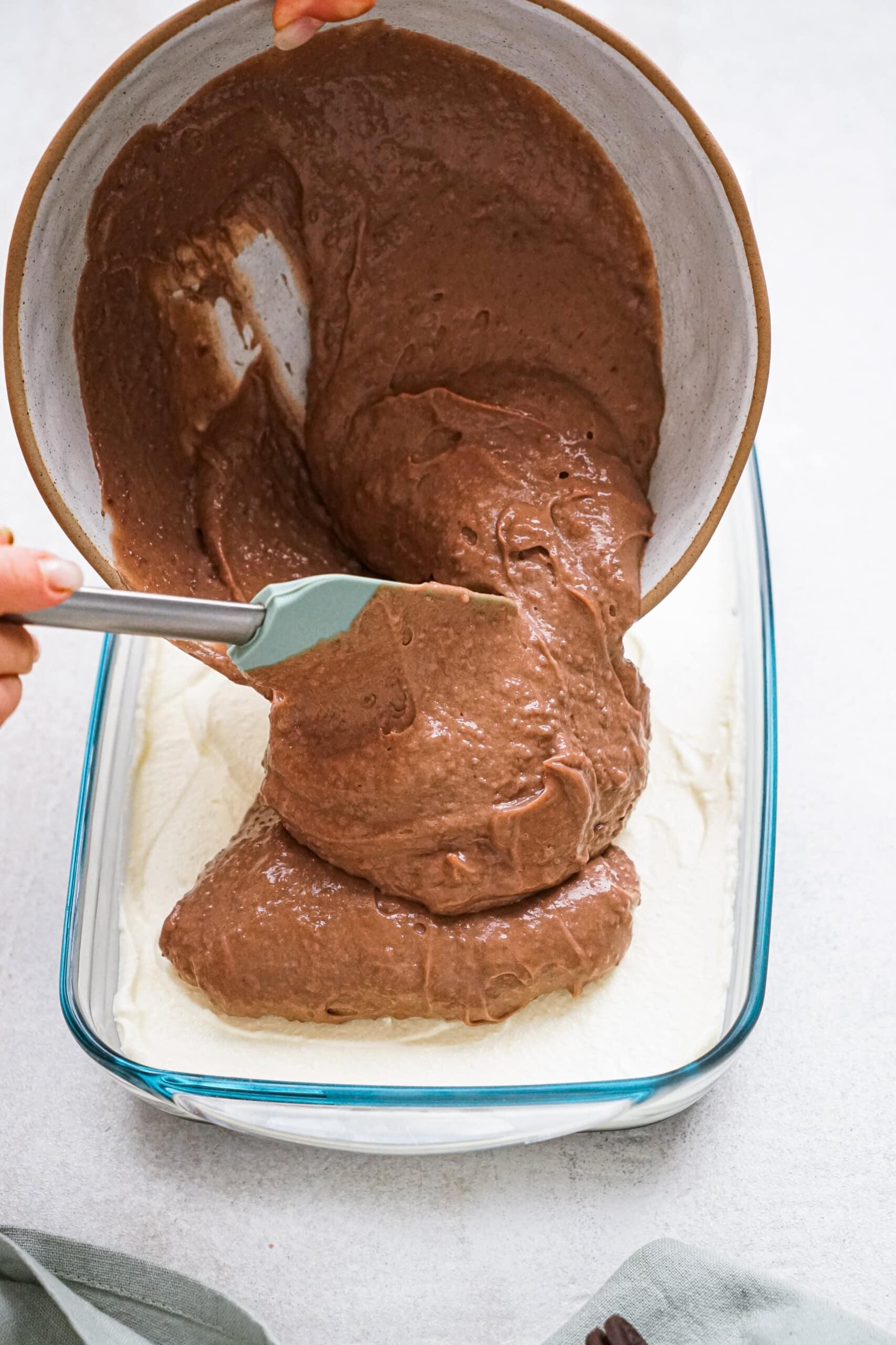 chocolate pudding being spread across cake