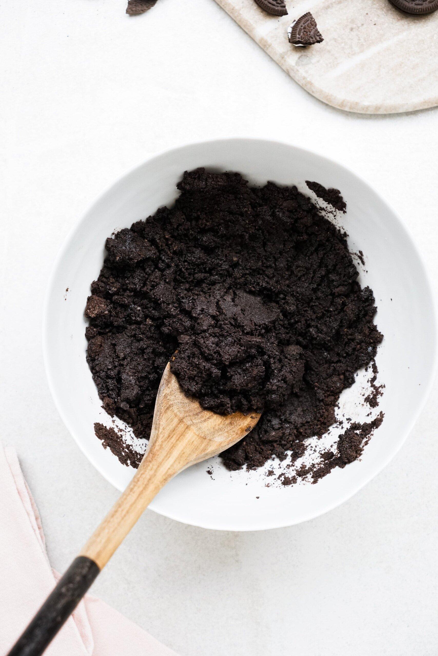 wooden spoon used to combine egg and Oreo crumbles