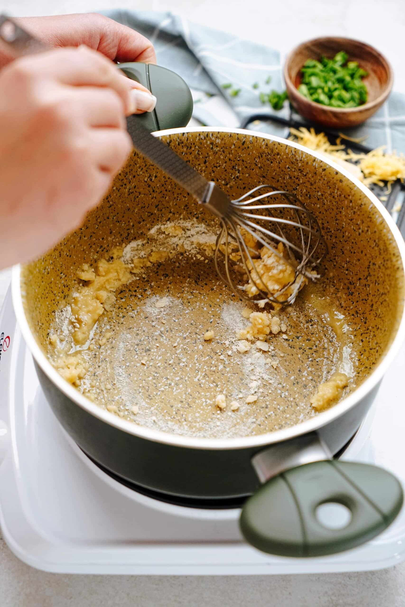 whisking a roux in a saucepan