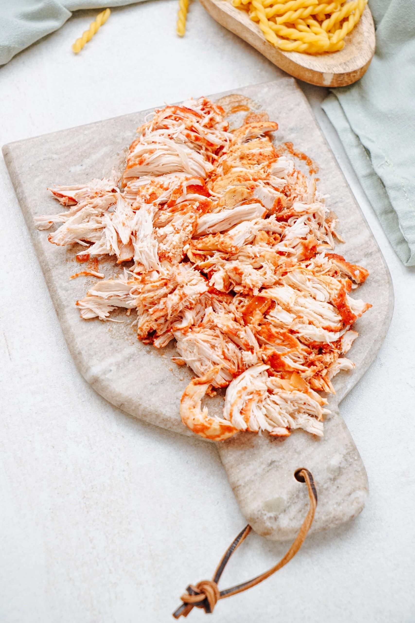 shredded chicken on a cutting board 