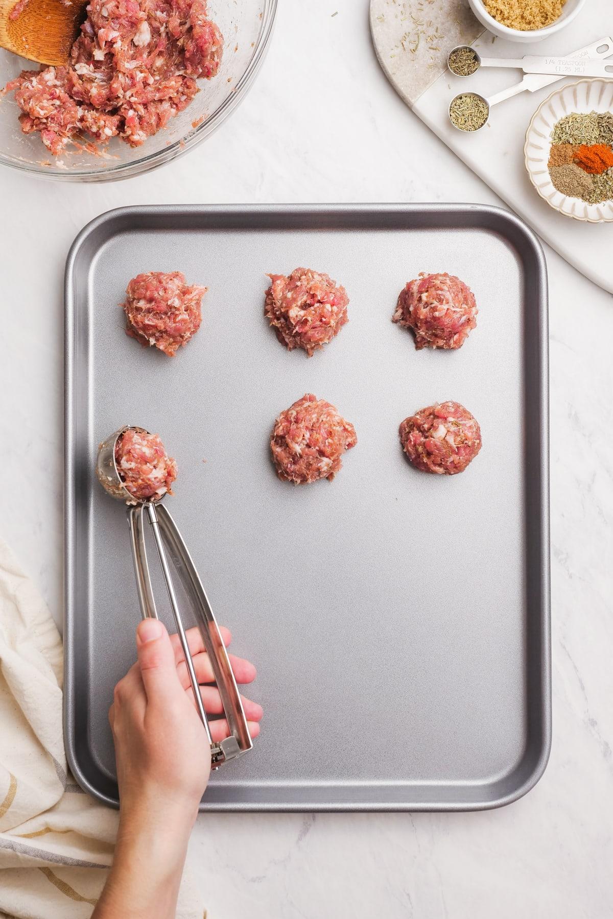 raw sausage balls on a baking sheet