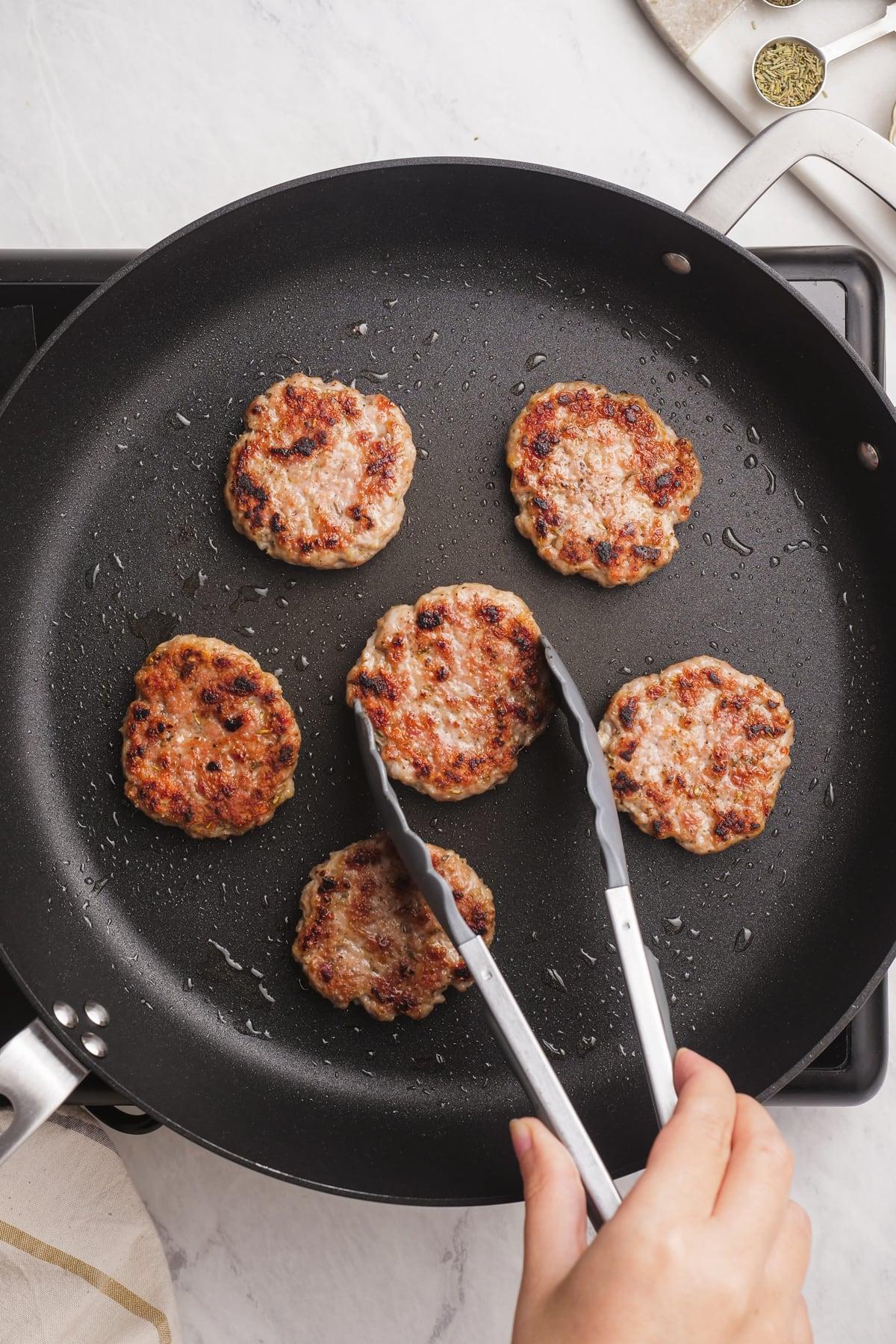 frying breakfast sausage in a pan