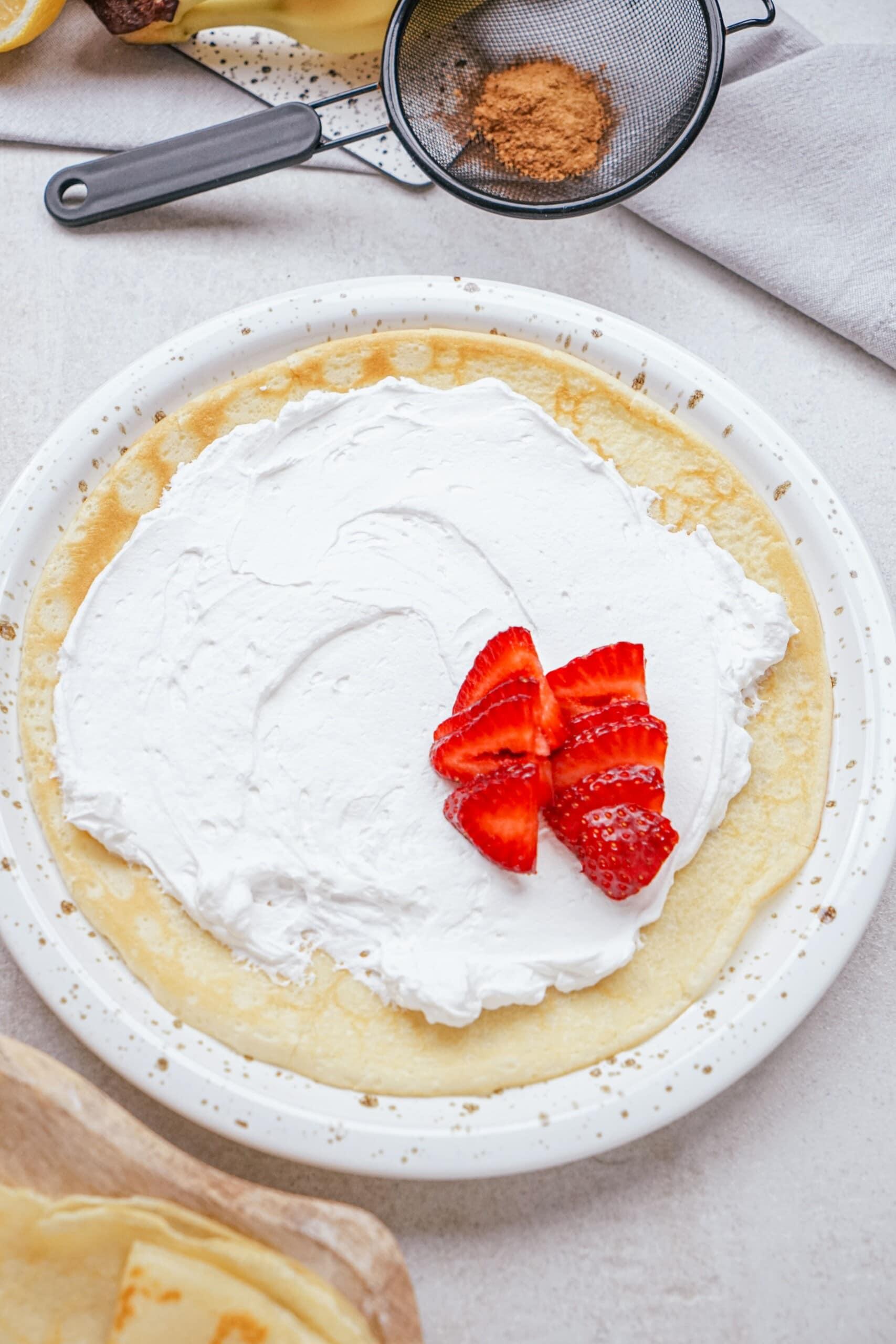 strawberries and whipped cream on a crepe