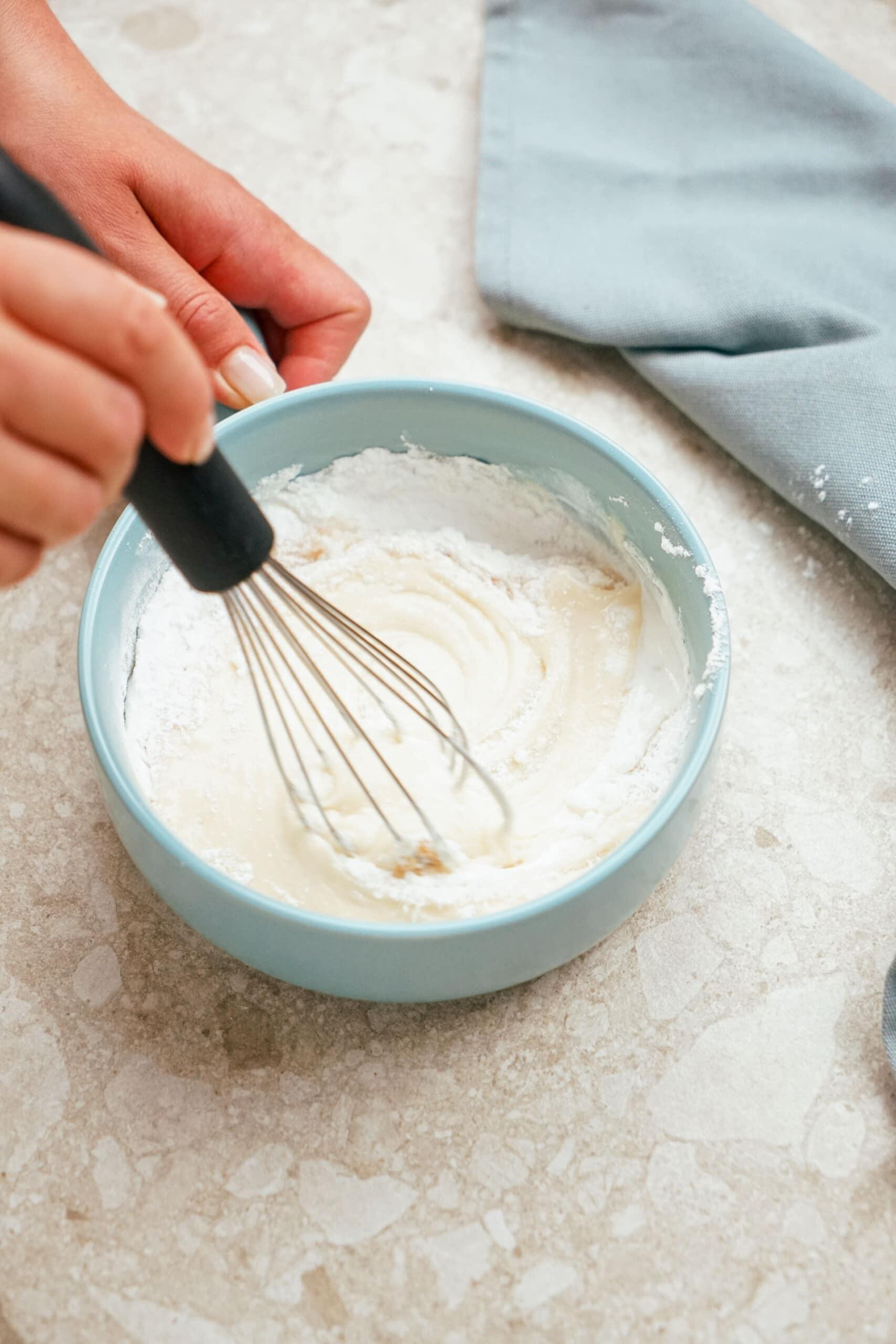 whisking icing together in a bowl