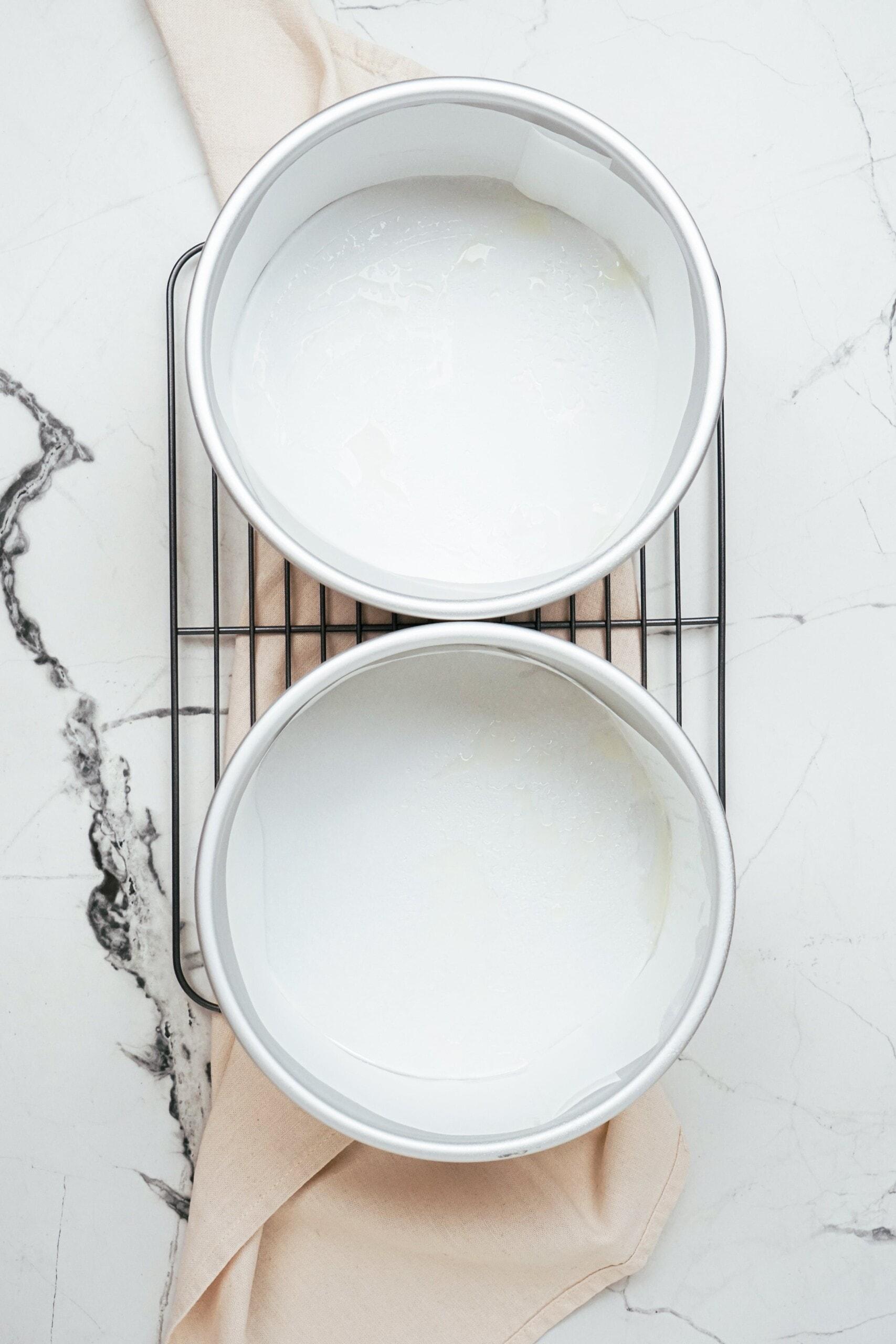 2 cake pans with parchment paper placed inside 