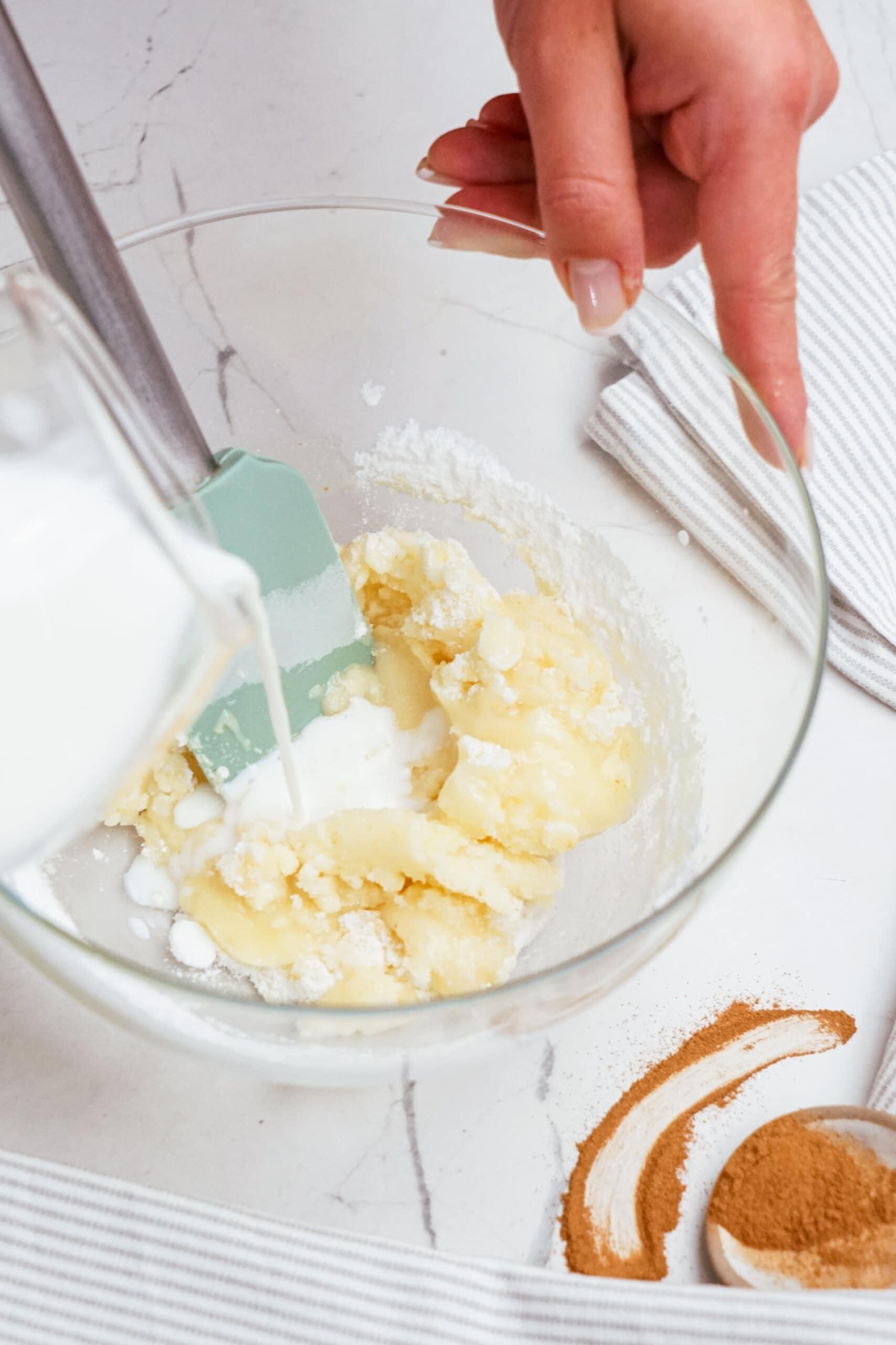 adding milk to powdered sugar and melted butter 