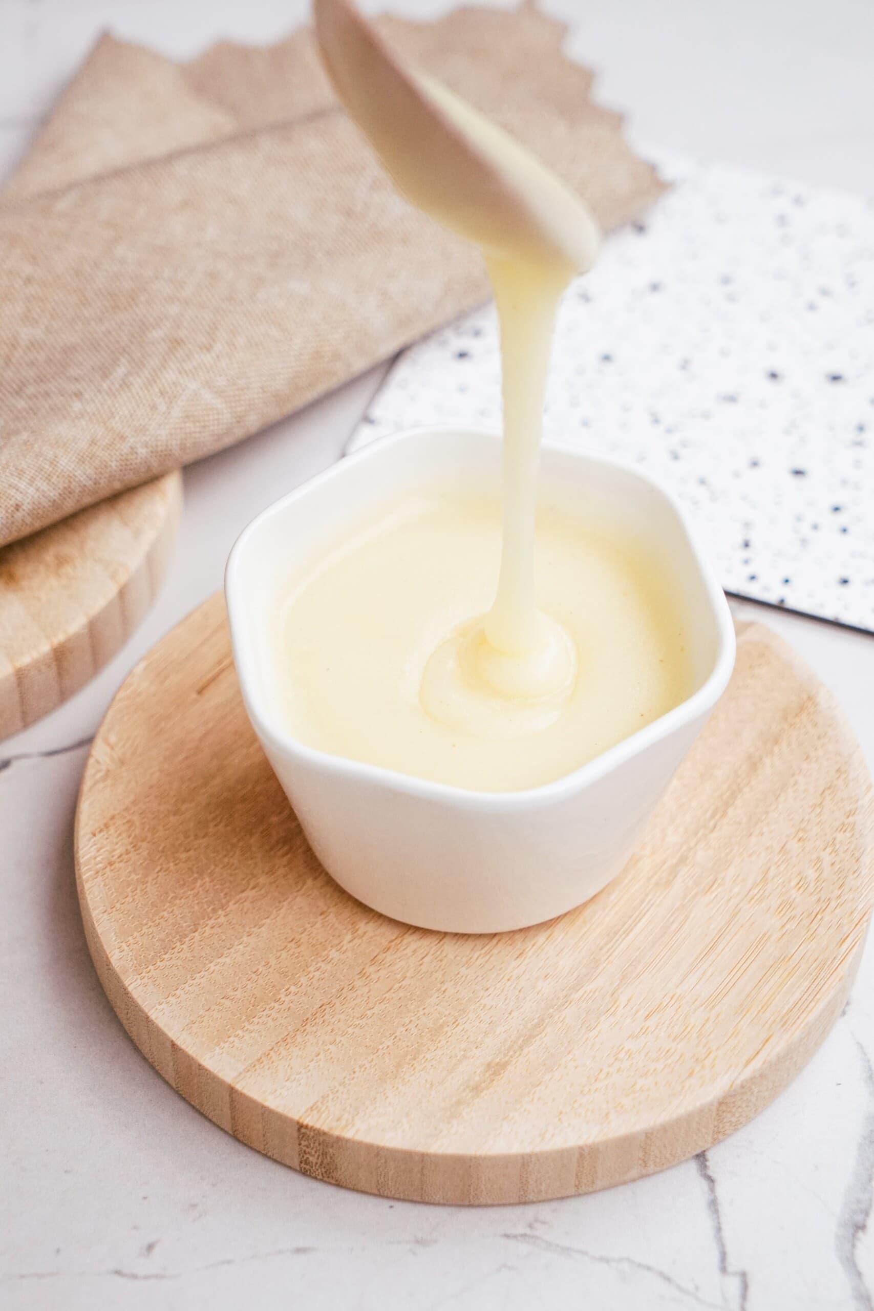 brown butter frosting poured into bowl with spoon