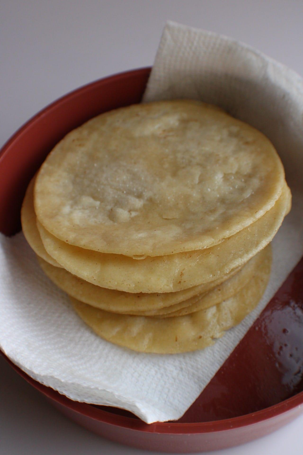 fried tortillas stacked one a paper towel