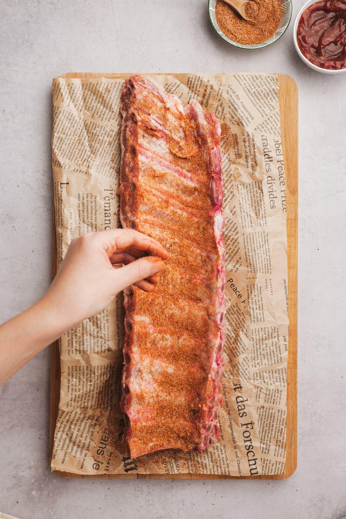 woman's hand seasoning ribs
