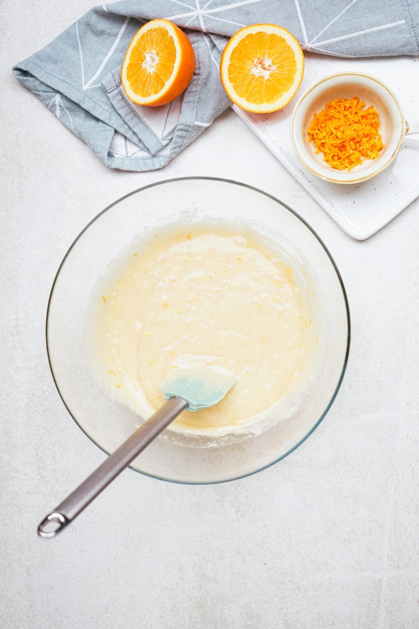 orange cupcakes batter with a rubber spatula