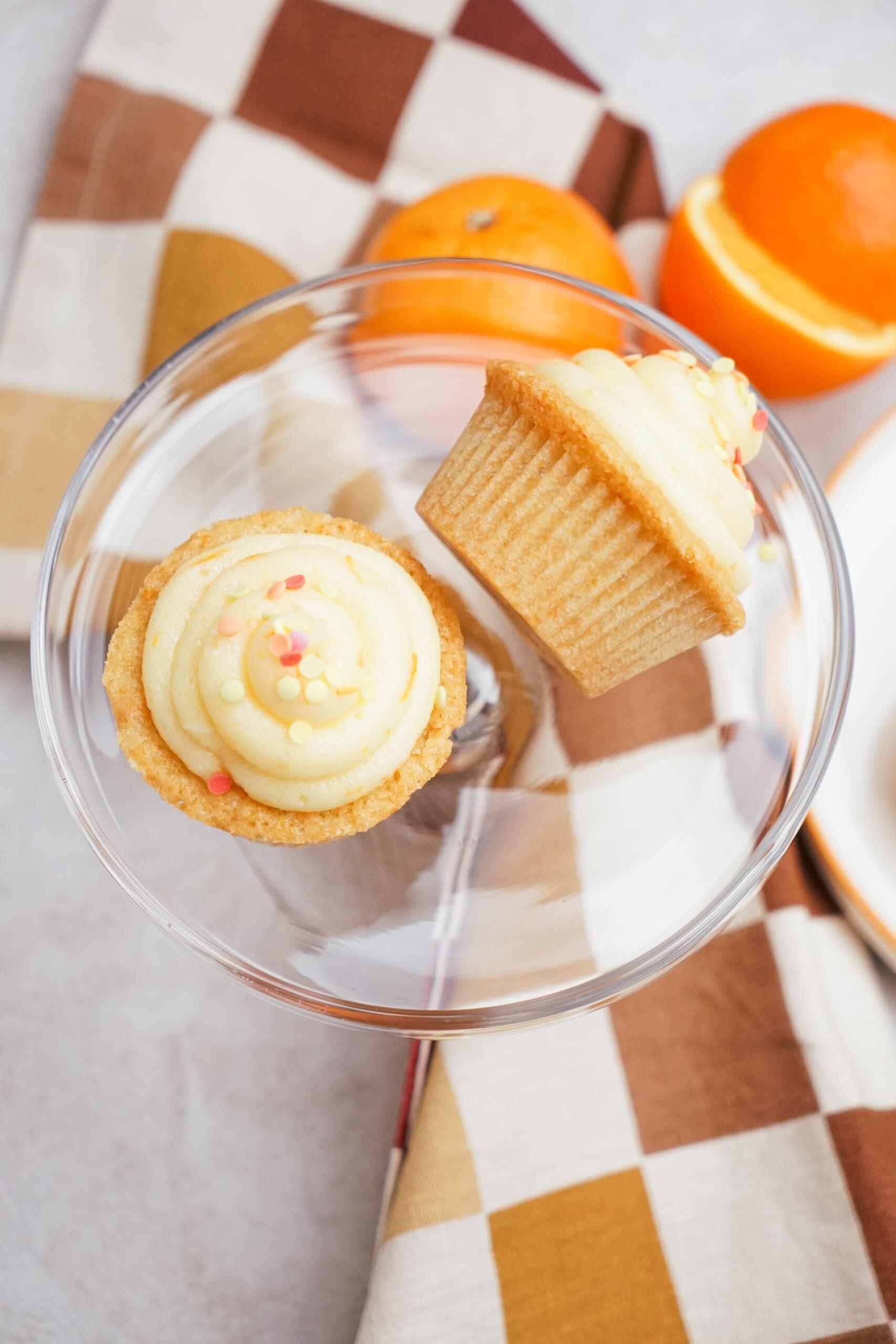 orange cupcakes on a clear glass plate- one cupcake on its side