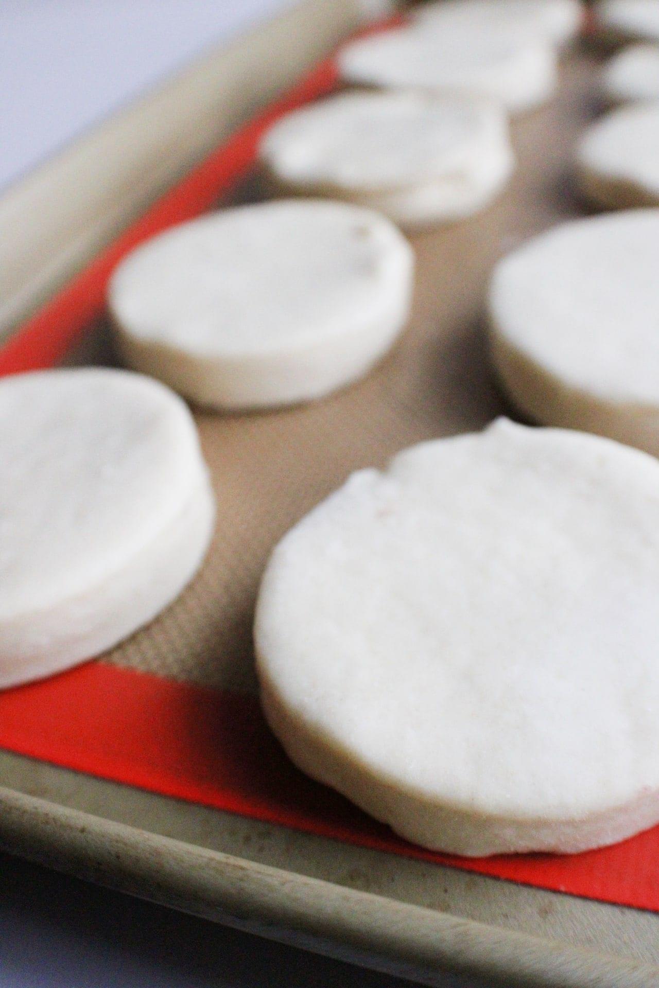 cut biscuit dough on baking pan 