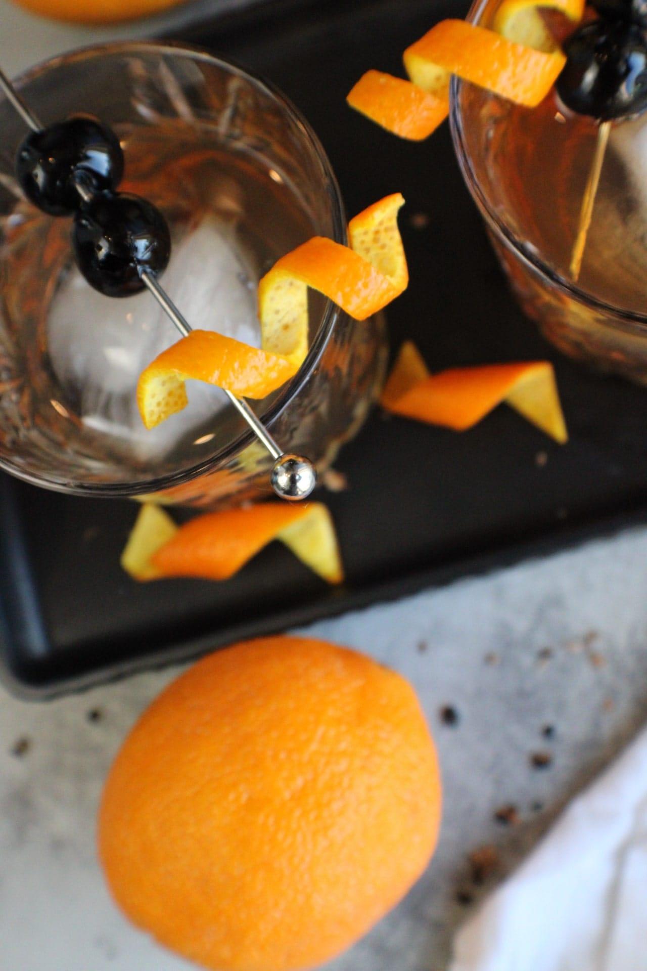 smoked old fashioned on black tray with orange