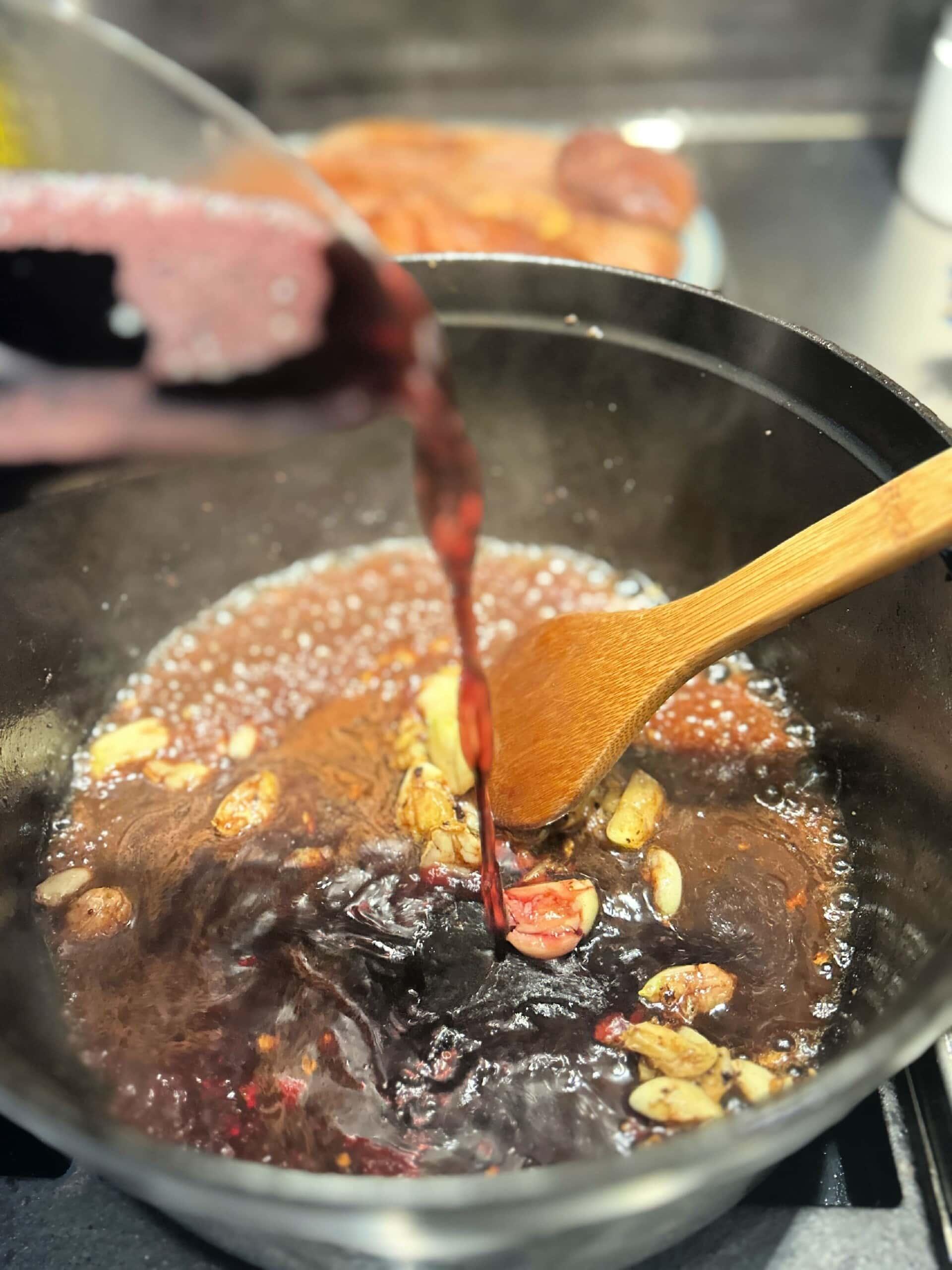 red wine added to the bottom of a dutch oven pan