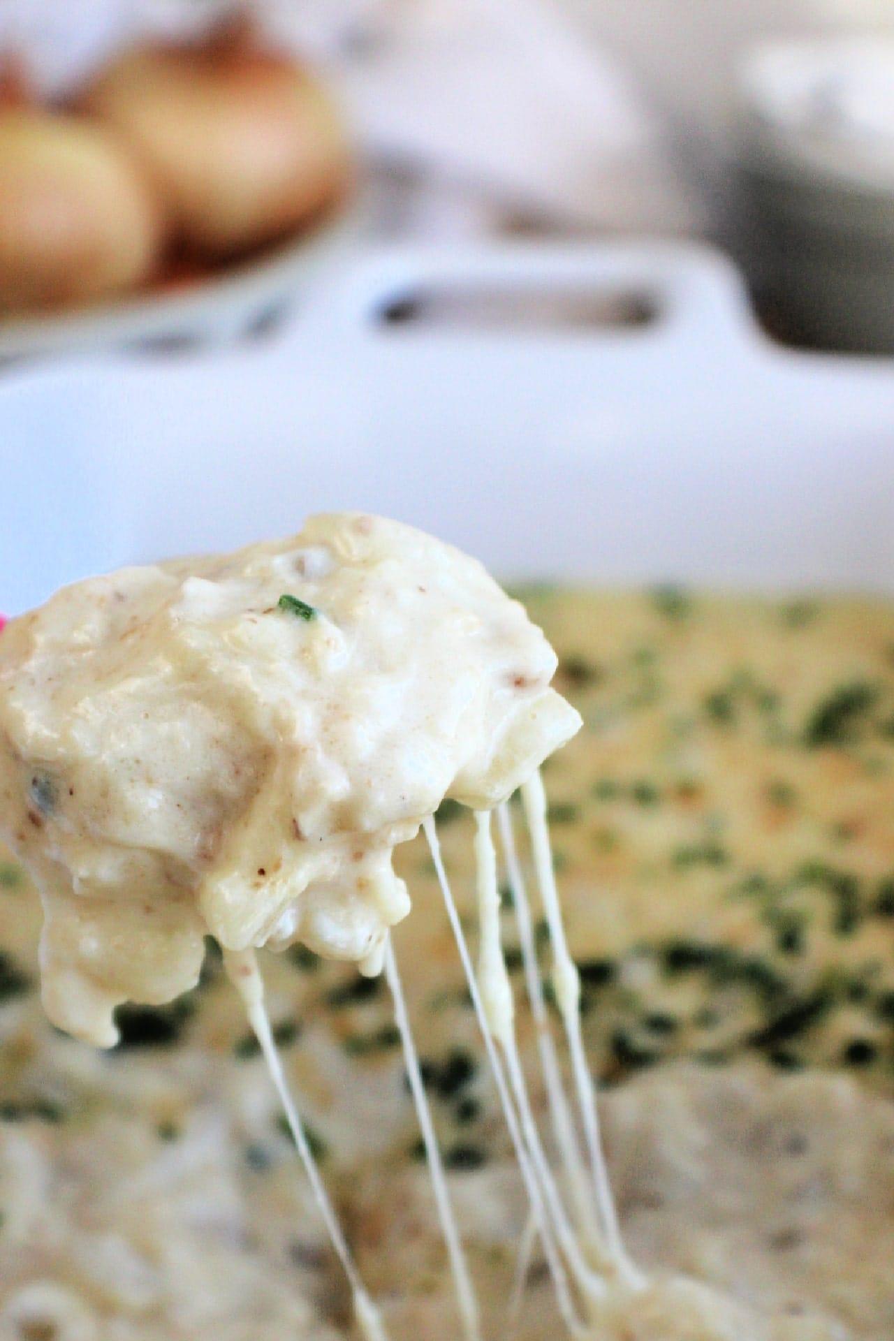 close up on heaping spoonful of Hot Onion Dip on a spoon