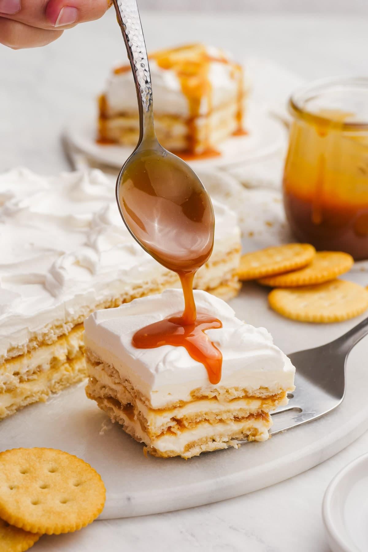 slice of salted caramel ritz cracker icebox cake with more caramel sauce being drizzled over the top