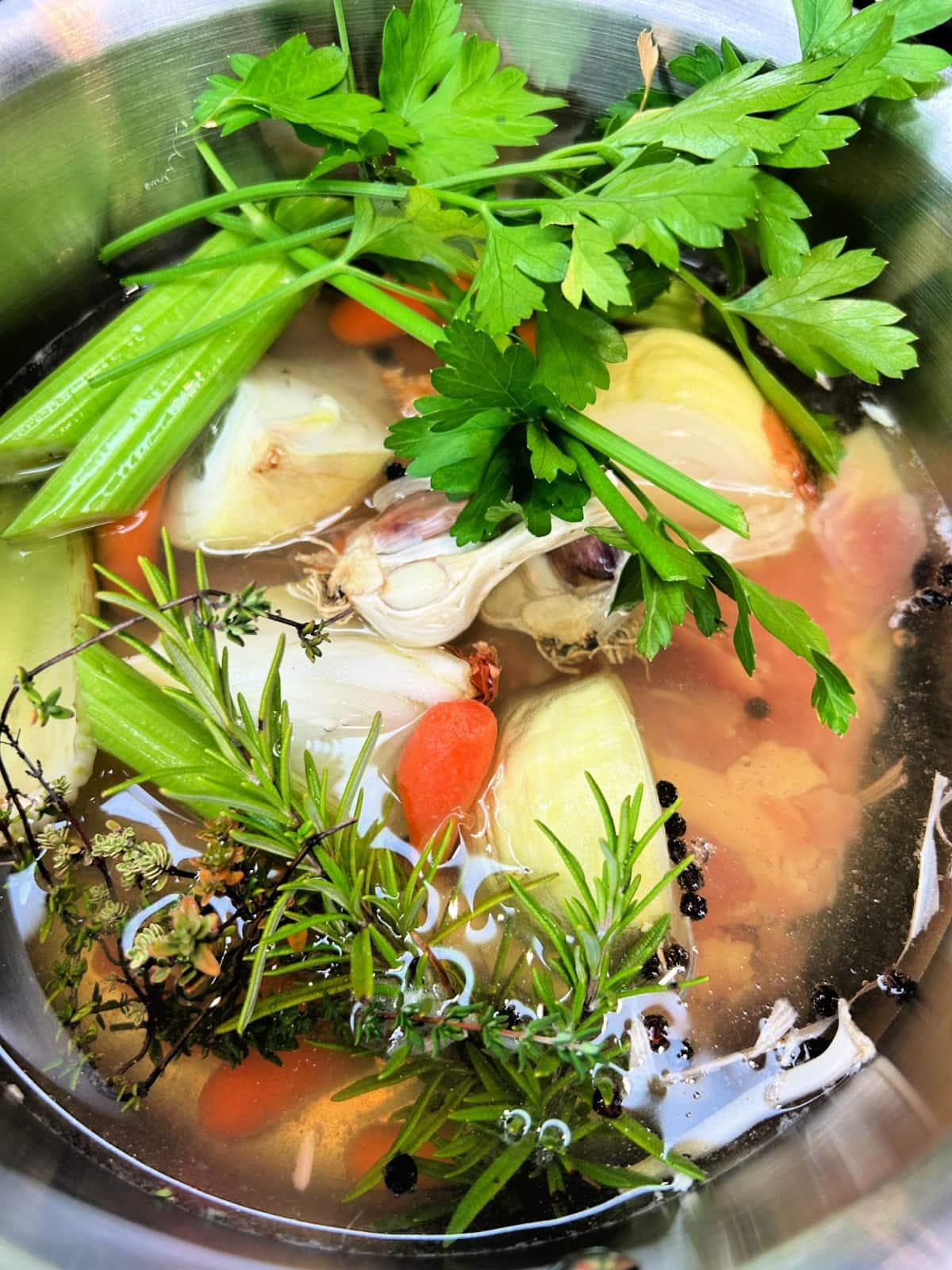 chicken thighs and veggies added to a saucepan