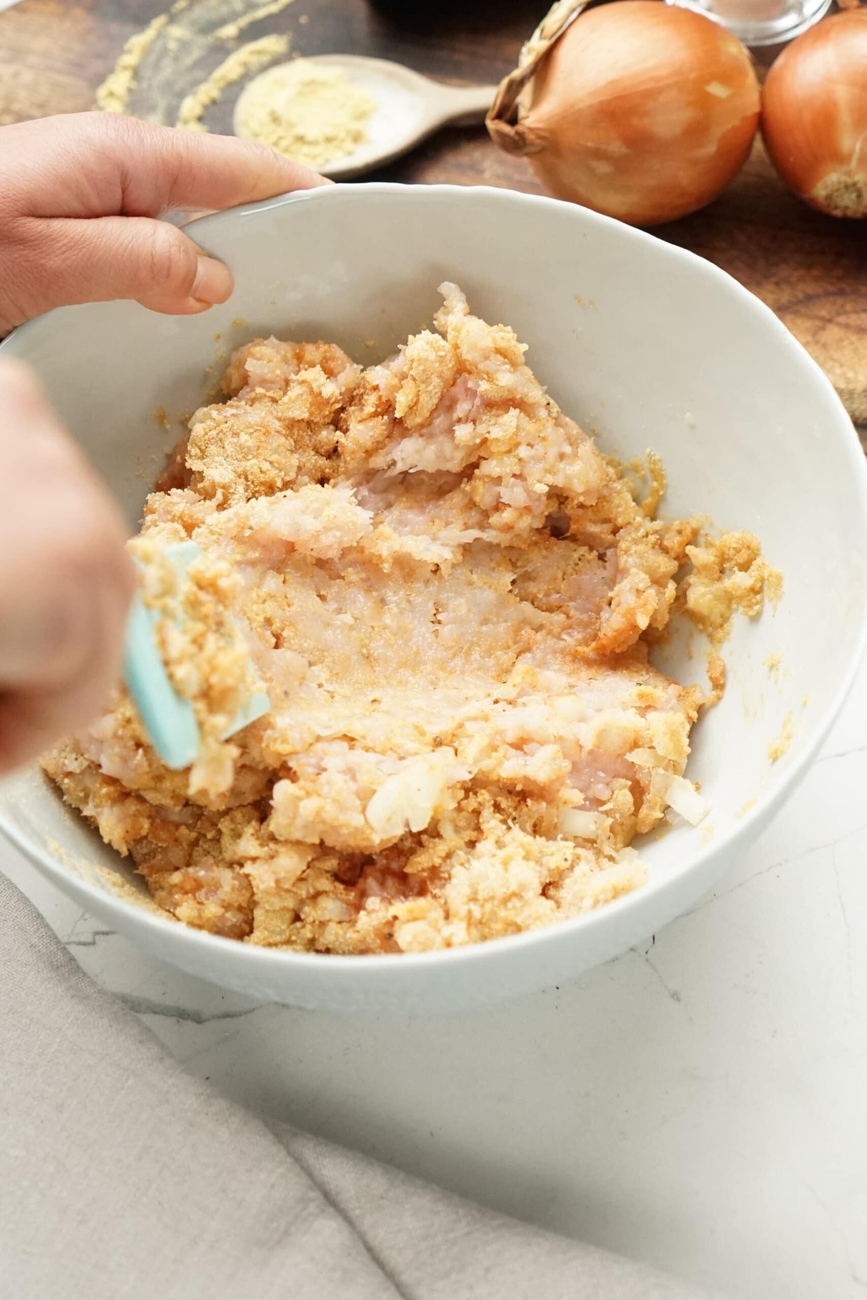 woman's hand using a rubber spatula to mix turkey mixture