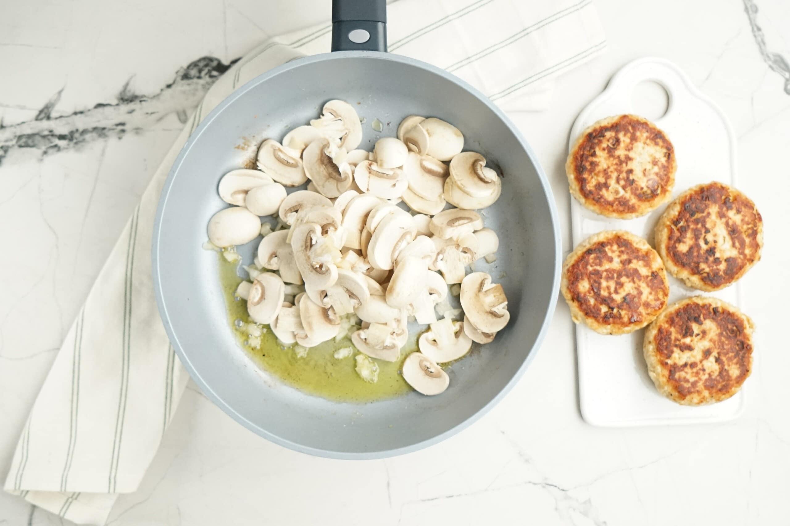 mushroom slices and onions sautéing in a pan