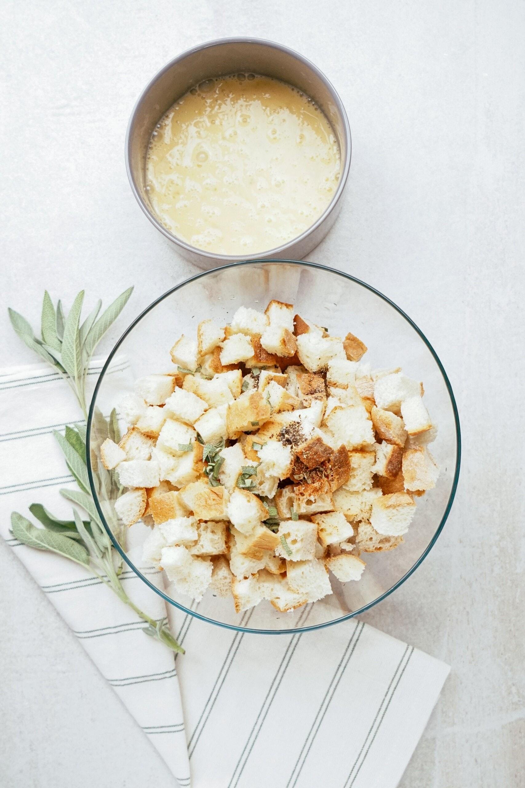 bread cubes in a glass bowl next to beaten eggs in a smaller bowl