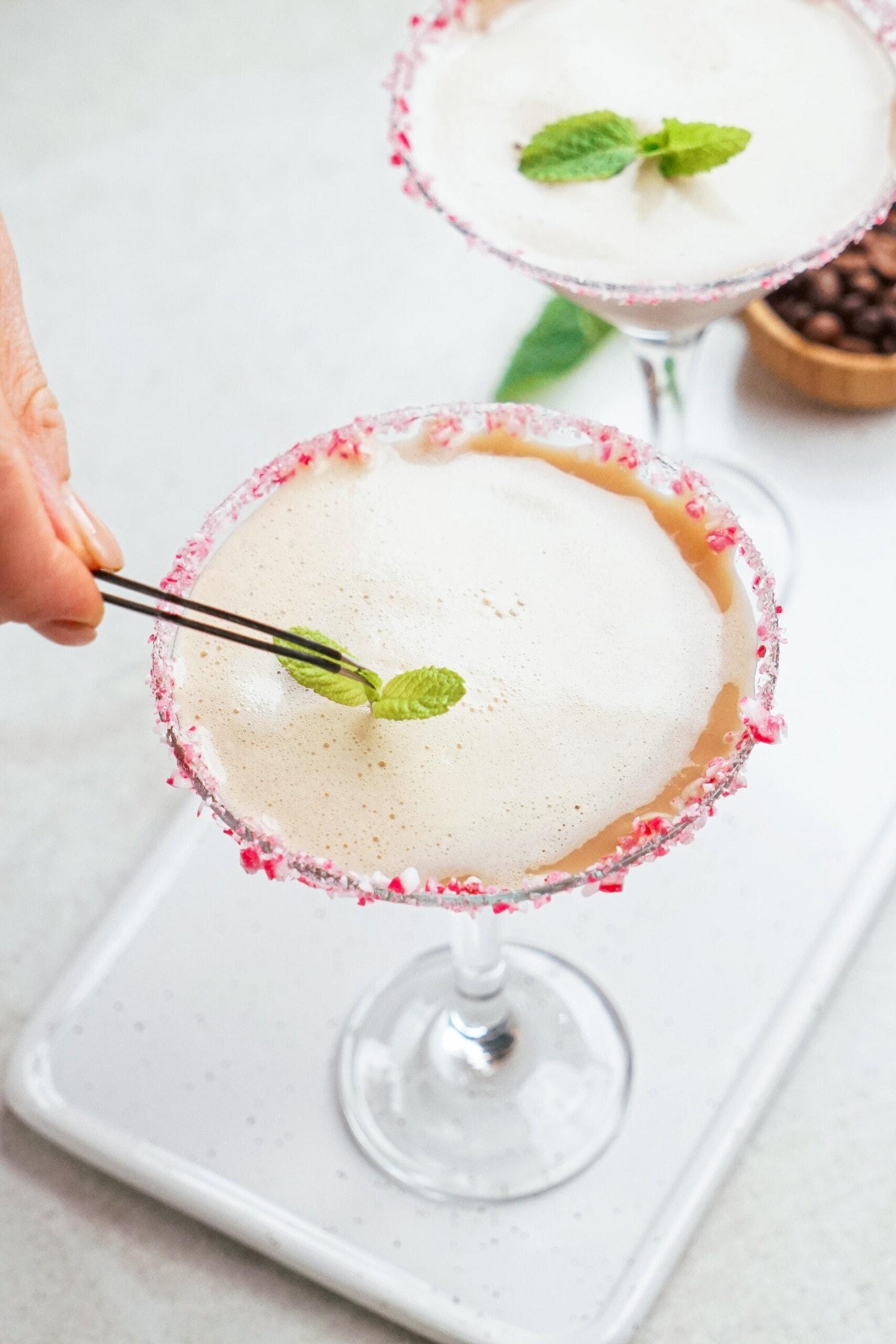 adding fresh mint with tweezers to martini
