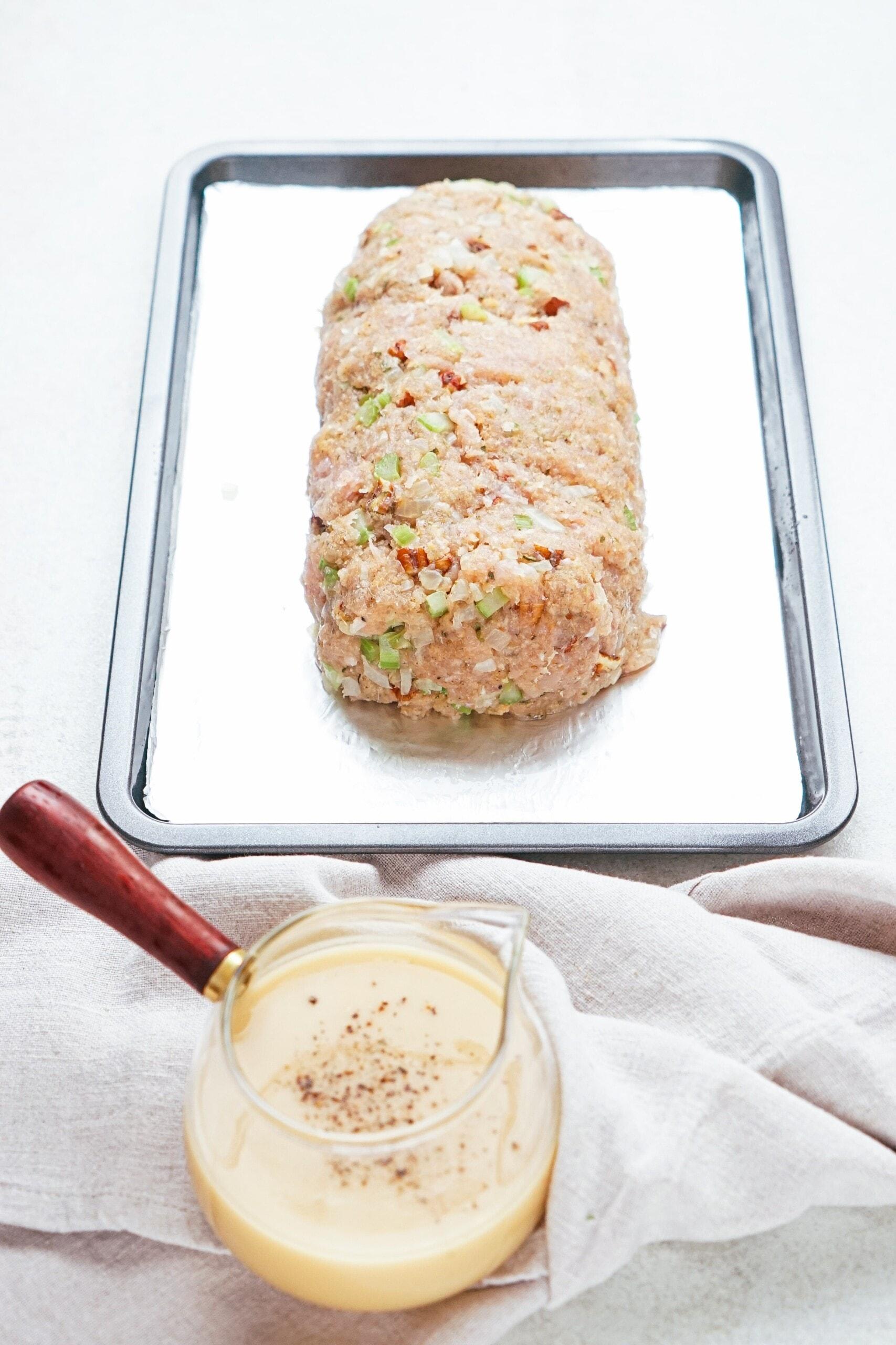 meatloaf mixture formed into a loaf on a baking sheet