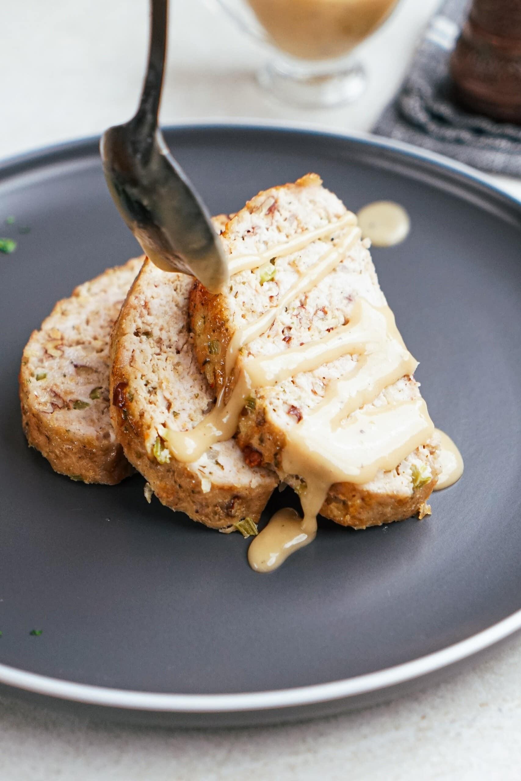 slices of meatloaf with gravy drizzled over the top