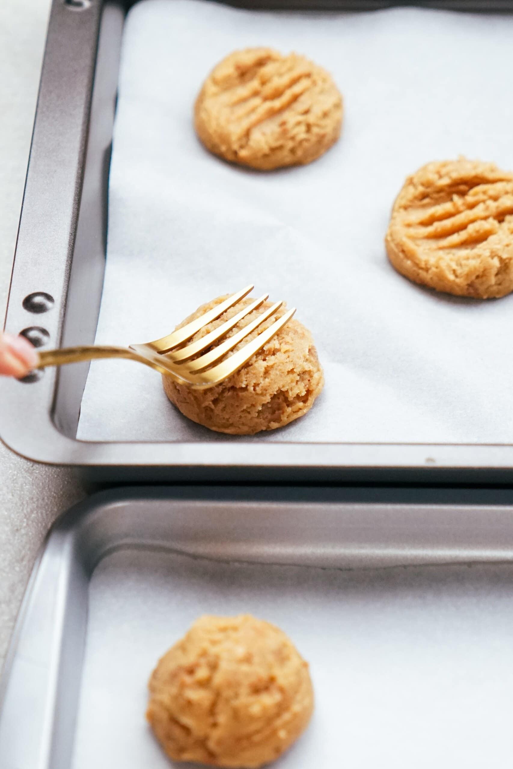 a fork flattening cookie dough balls