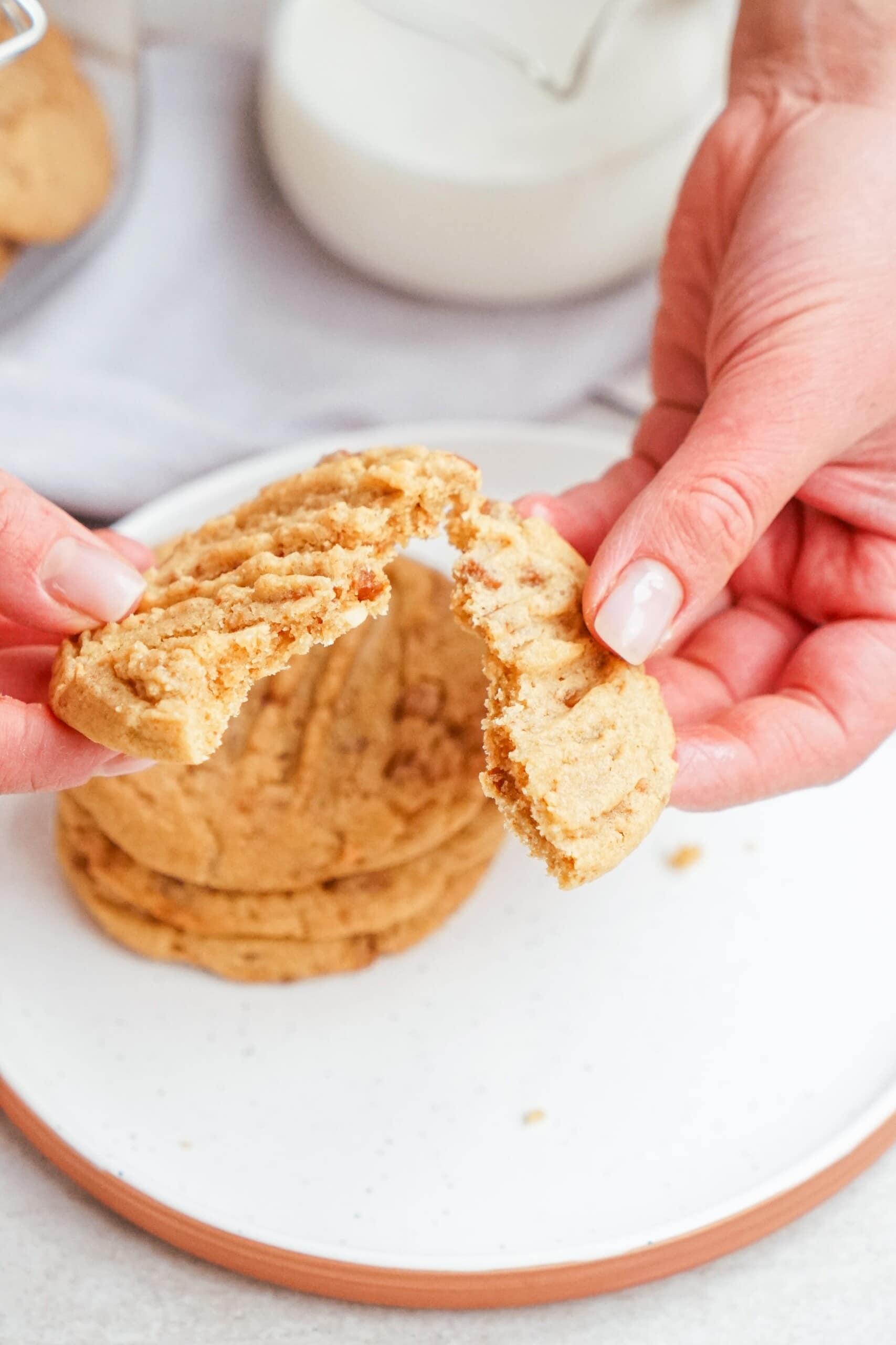 womans hands breaking a cookie in half 