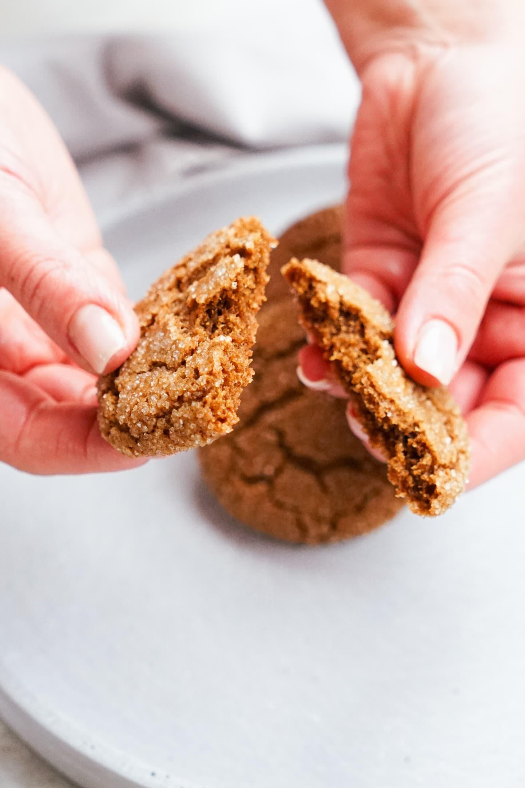 womans hand snapping a cookie in half 