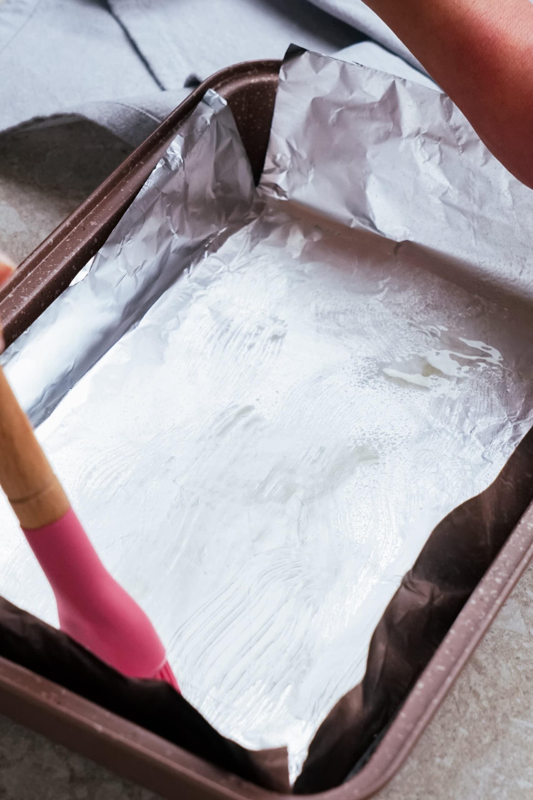 pan with foil and butter being brushed across