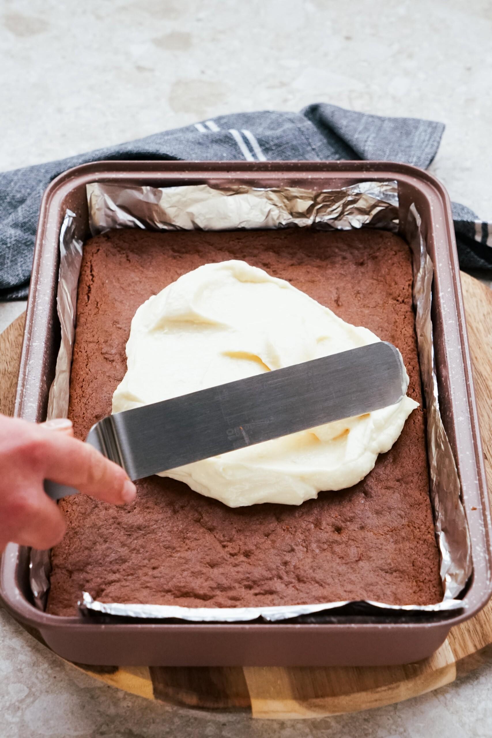 frosting being spread onto gingerbread bars