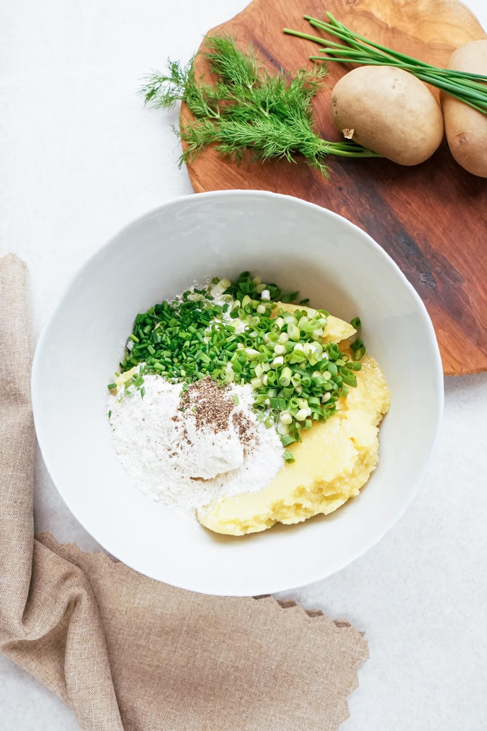 mashed potatoes and green onions and chives in a bowl. 