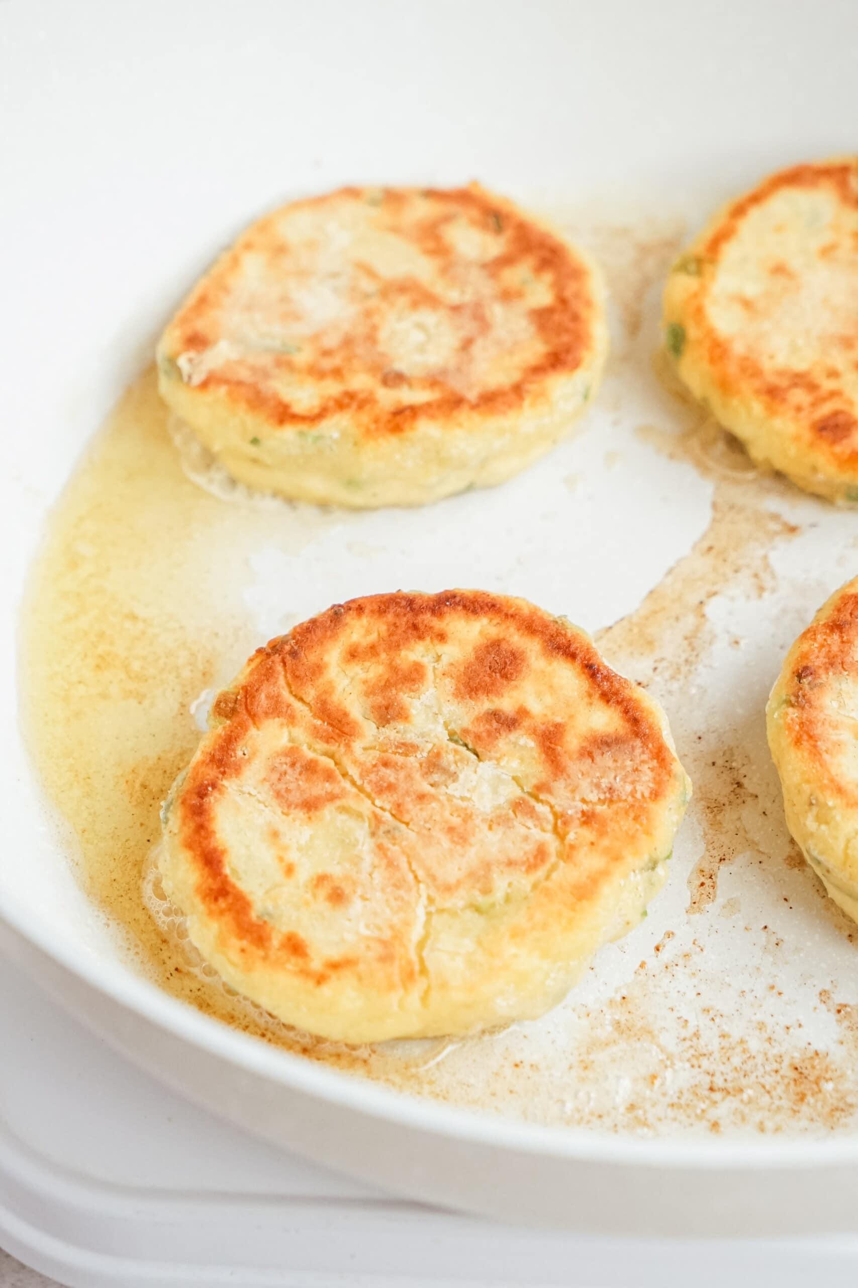 potato patties frying in a skillet