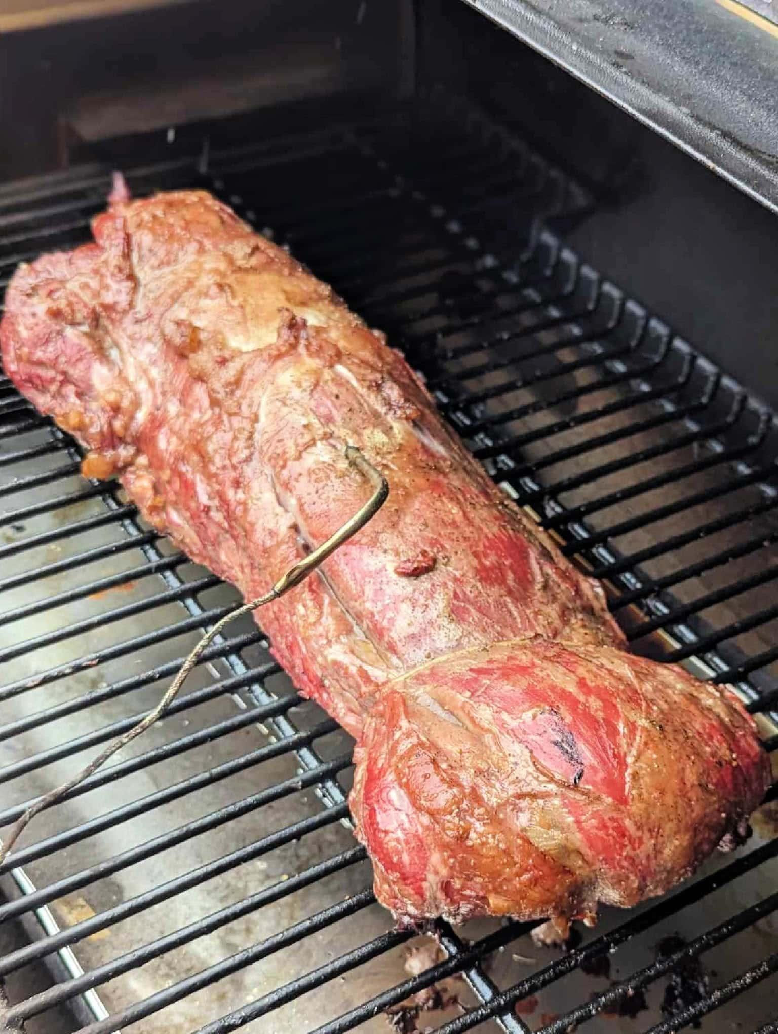 smoked beef tenderloin on smoker with probe inserted