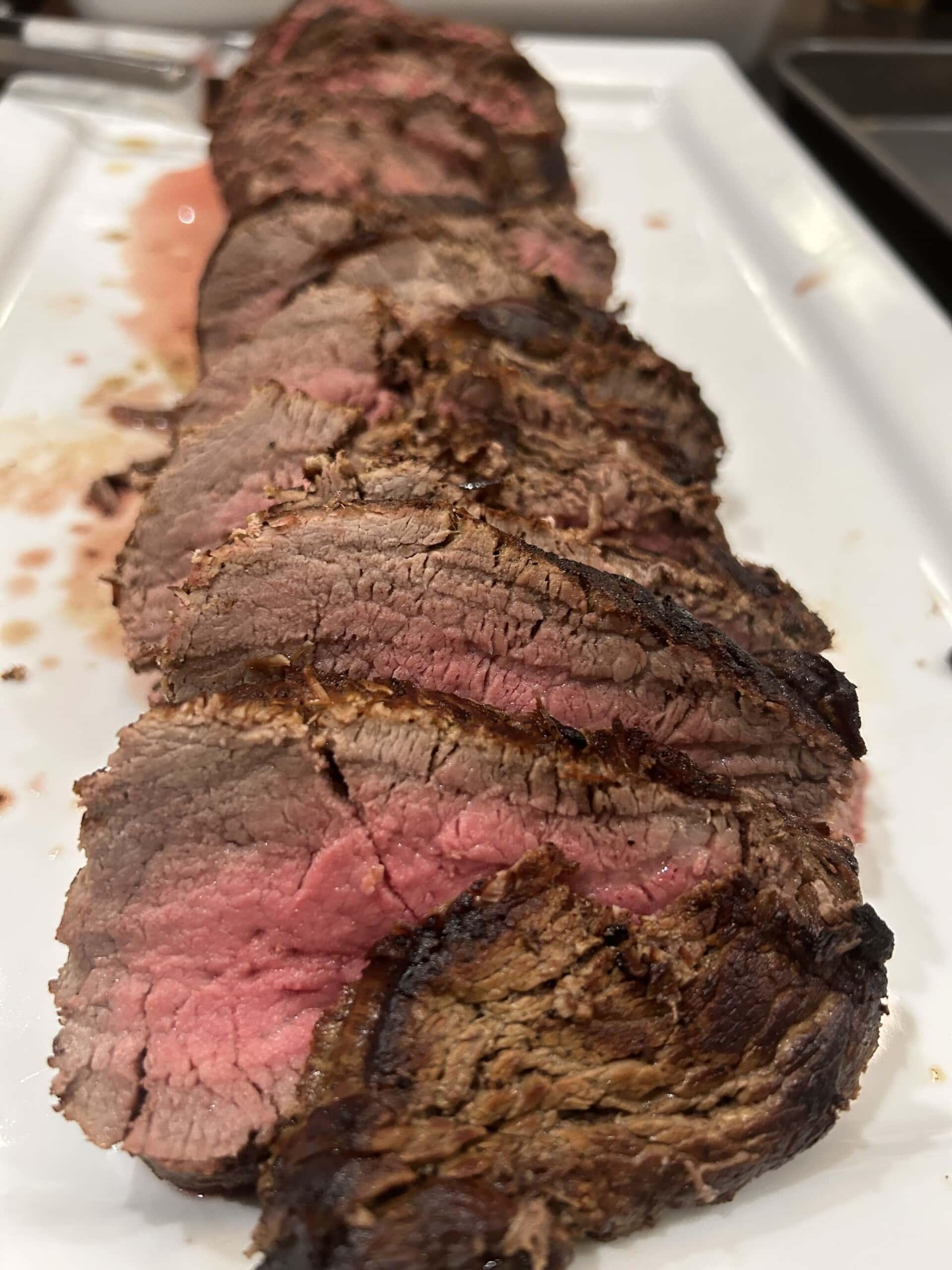 sliced smoked beef tenderloin on white platter