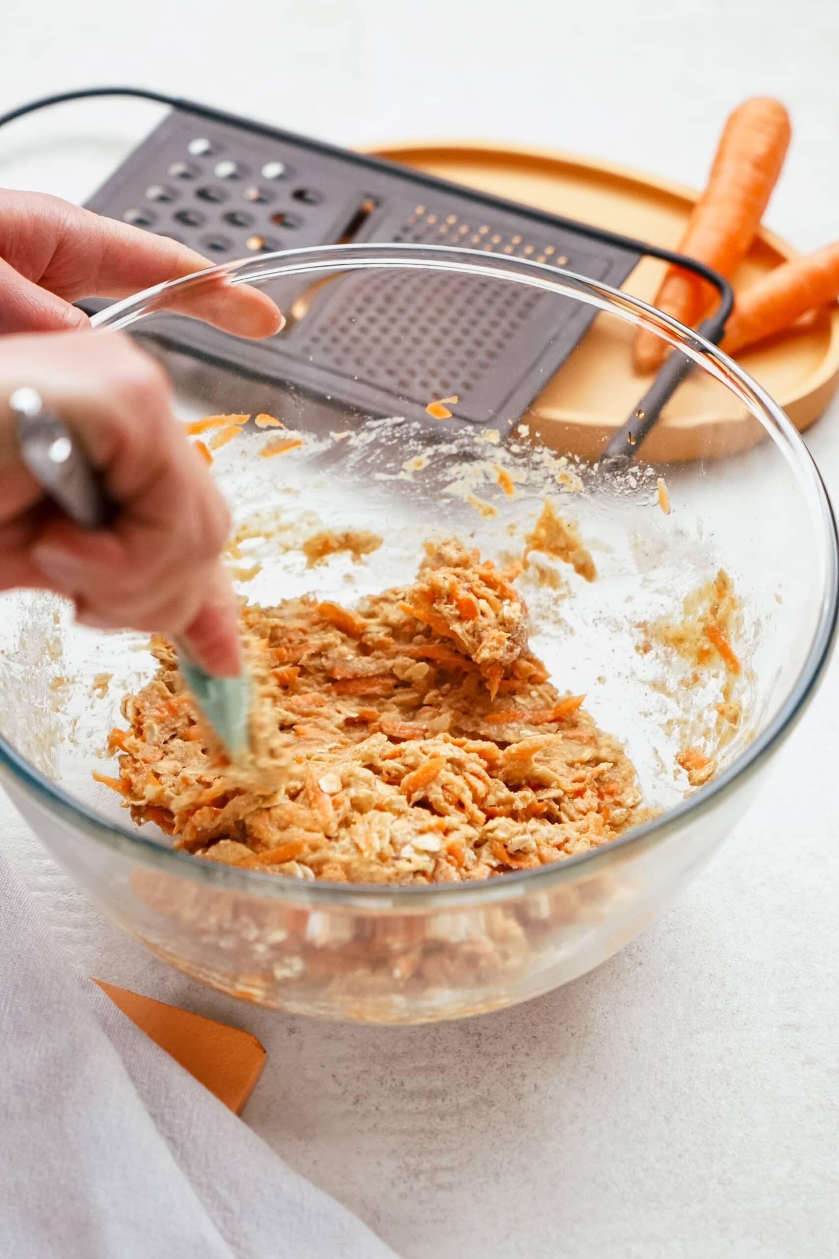 womans hand incorporating dry ingredients into wet ingredients 