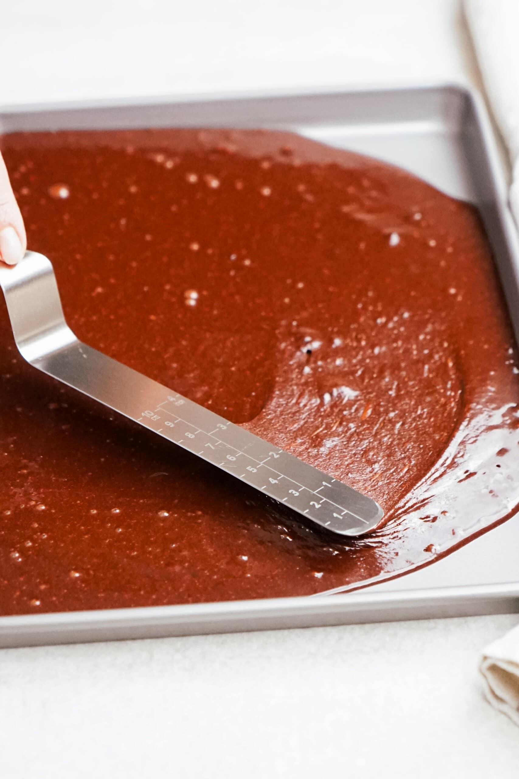 spatula smoothing cake batter into the pan