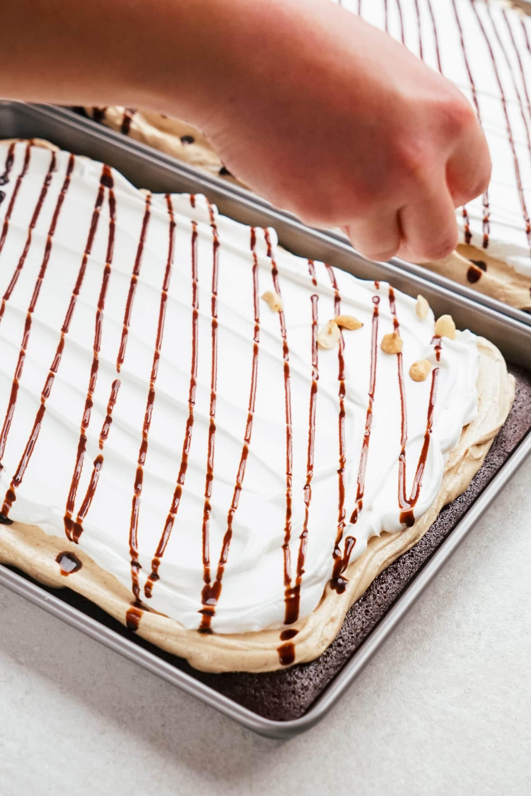 chocolate syrup being drizzled across the cake