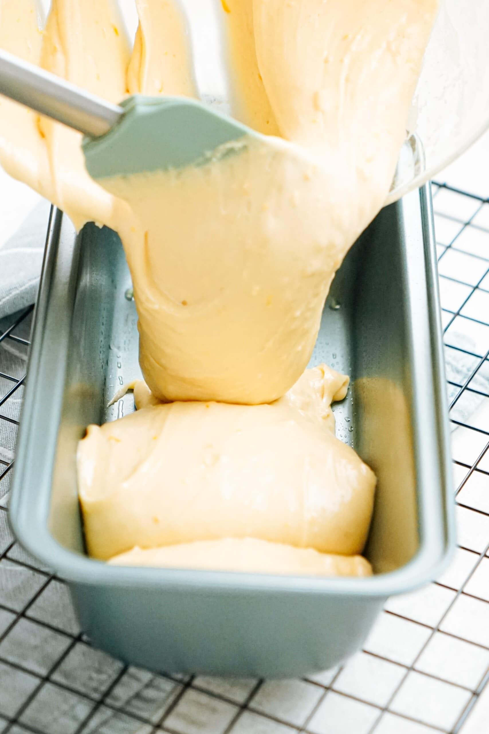 lemon cake batter being poured into the loaf pan