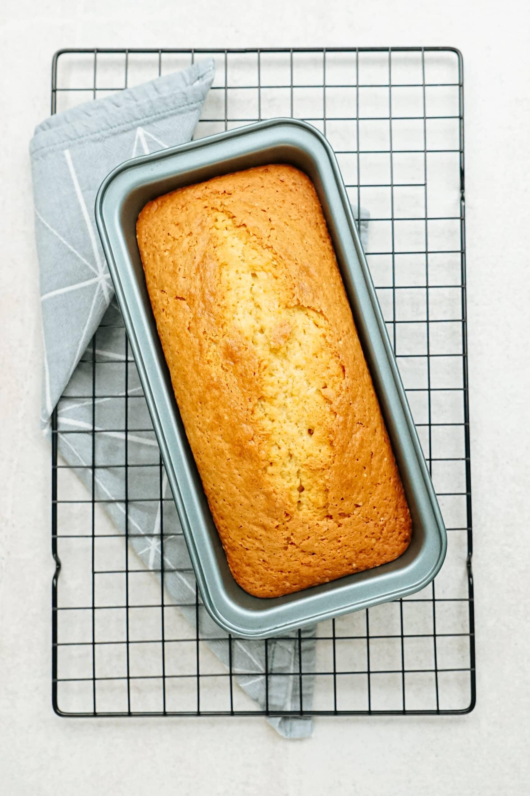 baked lemon pound cake in the loaf pan on a wire rack