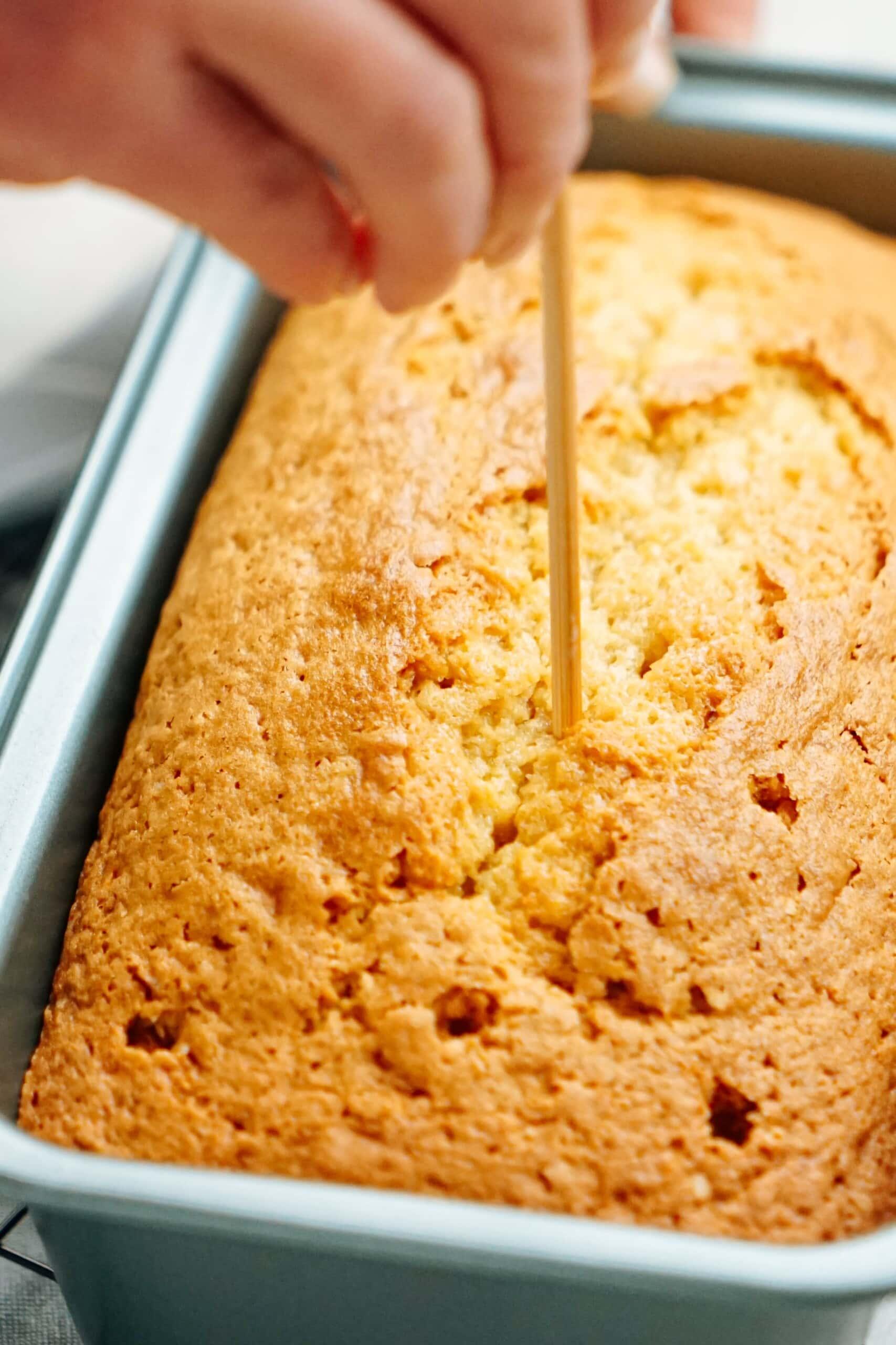 poking hole in the cake with a toothpick